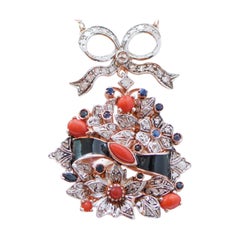 Collana con ciondolo in corallo, zaffiri, diamanti, smalto, oro rosa e argento.