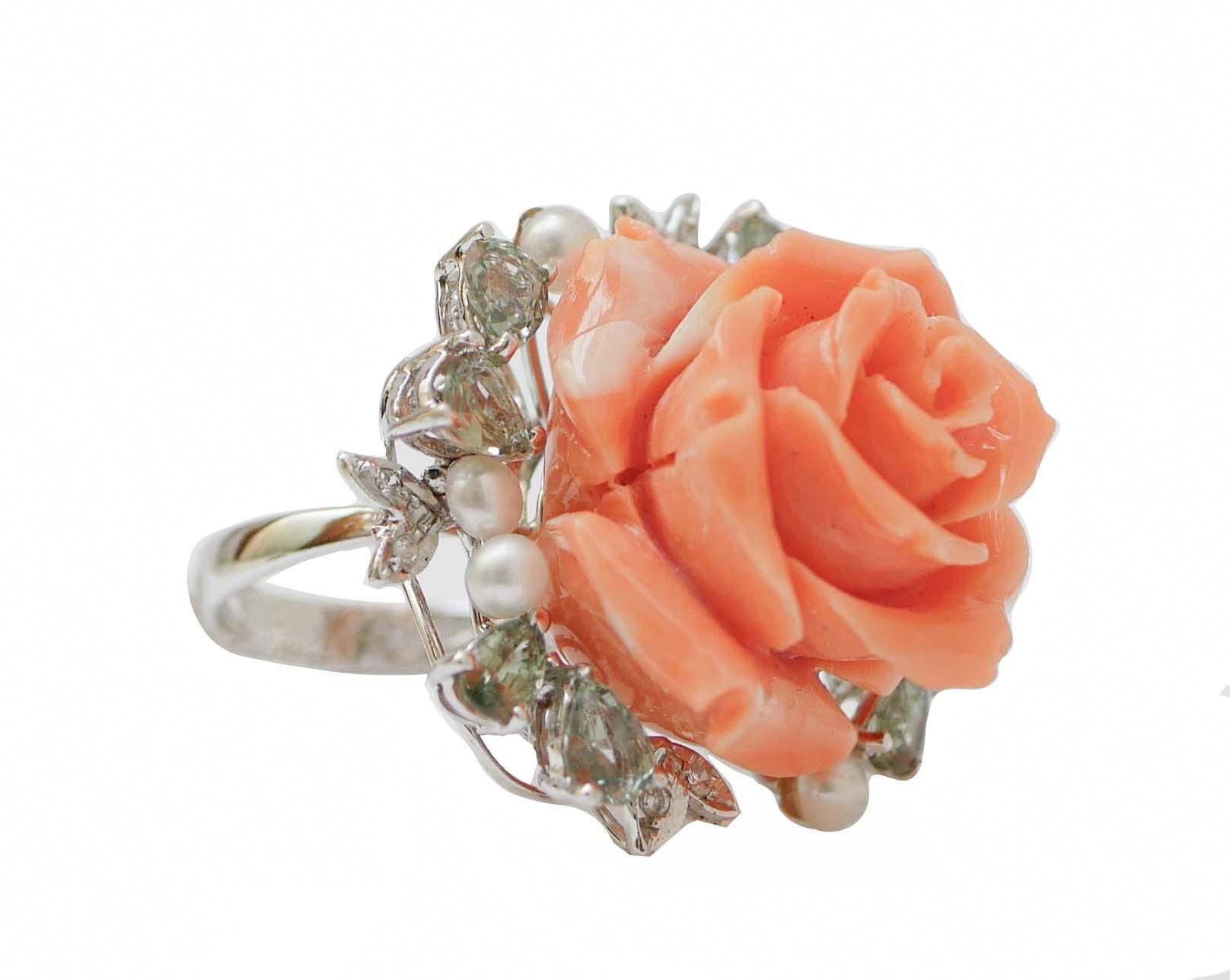  Fantastic ring in 14 kt white gold structure mounted with a flower of coral in the central part surrounded by green sapphires, diamonds and pearls.
This ring was totally handmade by Italian master goldsmiths and it is in perfect
