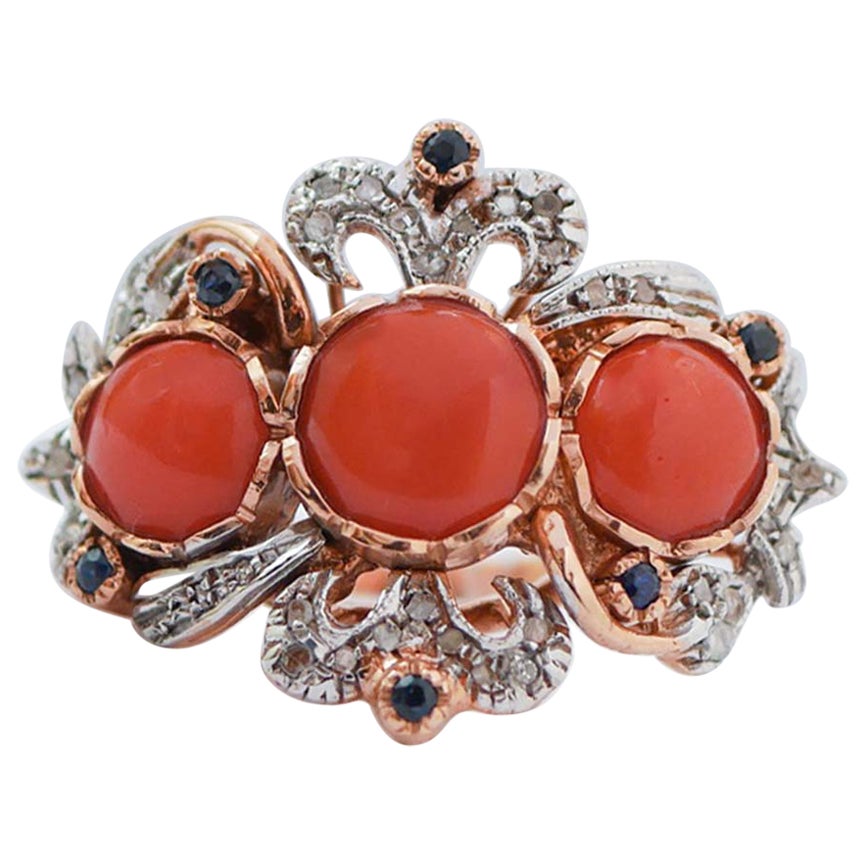 Anello in corallo, zaffiri, diamanti, oro rosa e argento.
