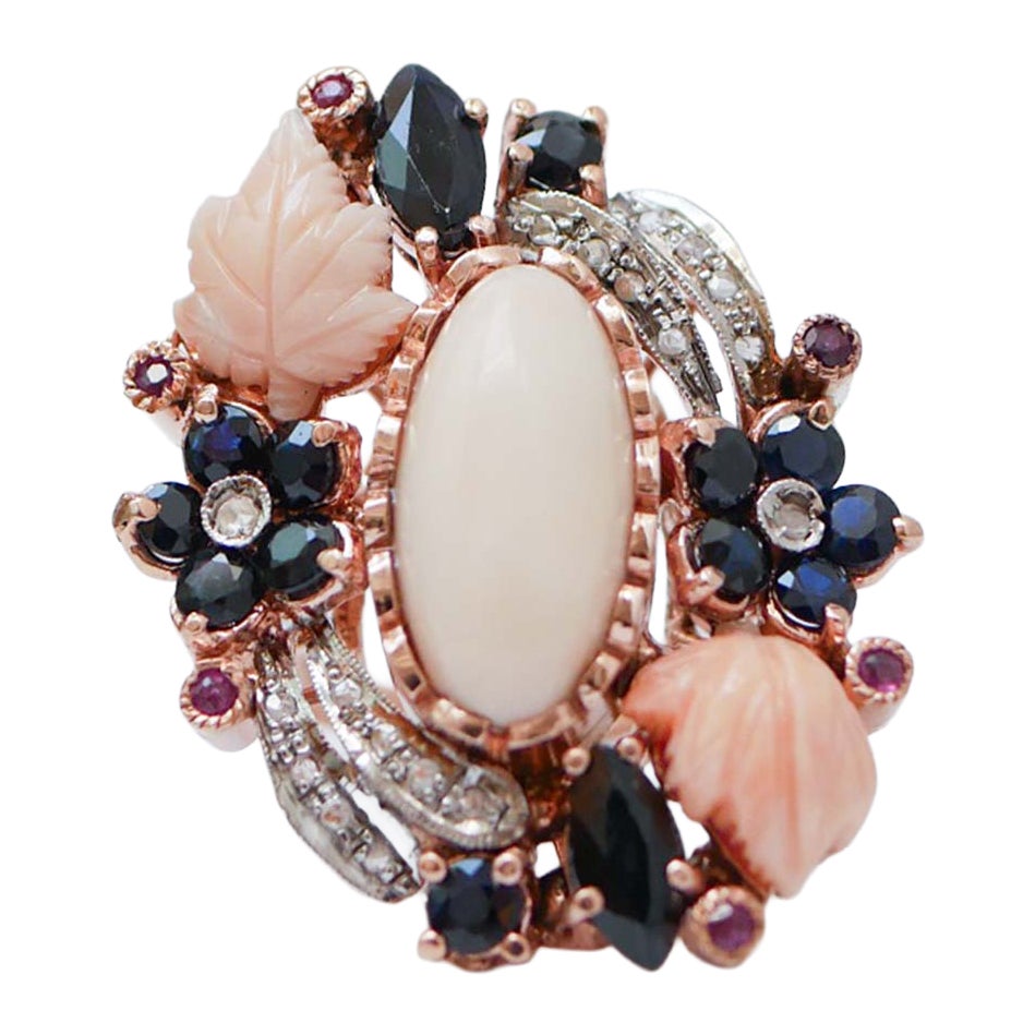 Anello con corallo, zaffiri, rubini, diamanti, oro rosa e argento.