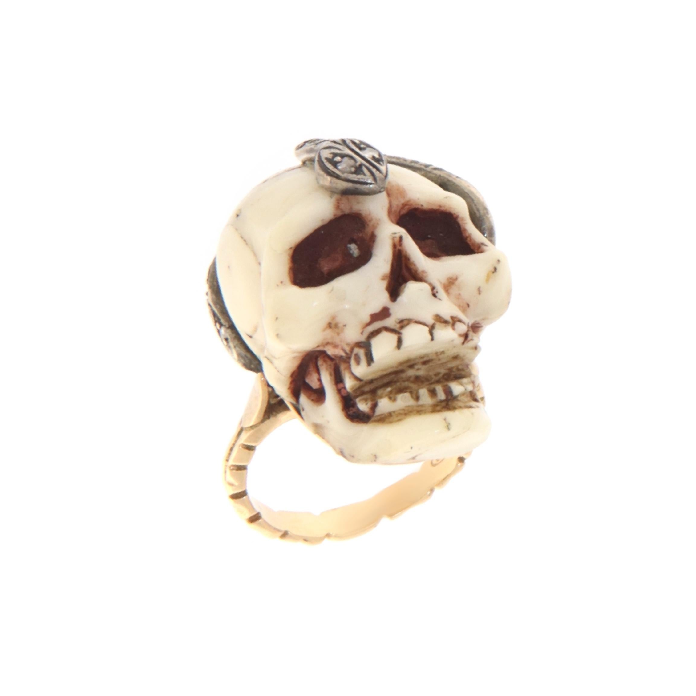 This bold ring merges artisanal craftsmanship with symbols rich in history, crafted in 14-karat yellow gold and 800 silver. The focal point is an intriguing coral skull, carved with impressive detail to capture the visceral essence and evocative
