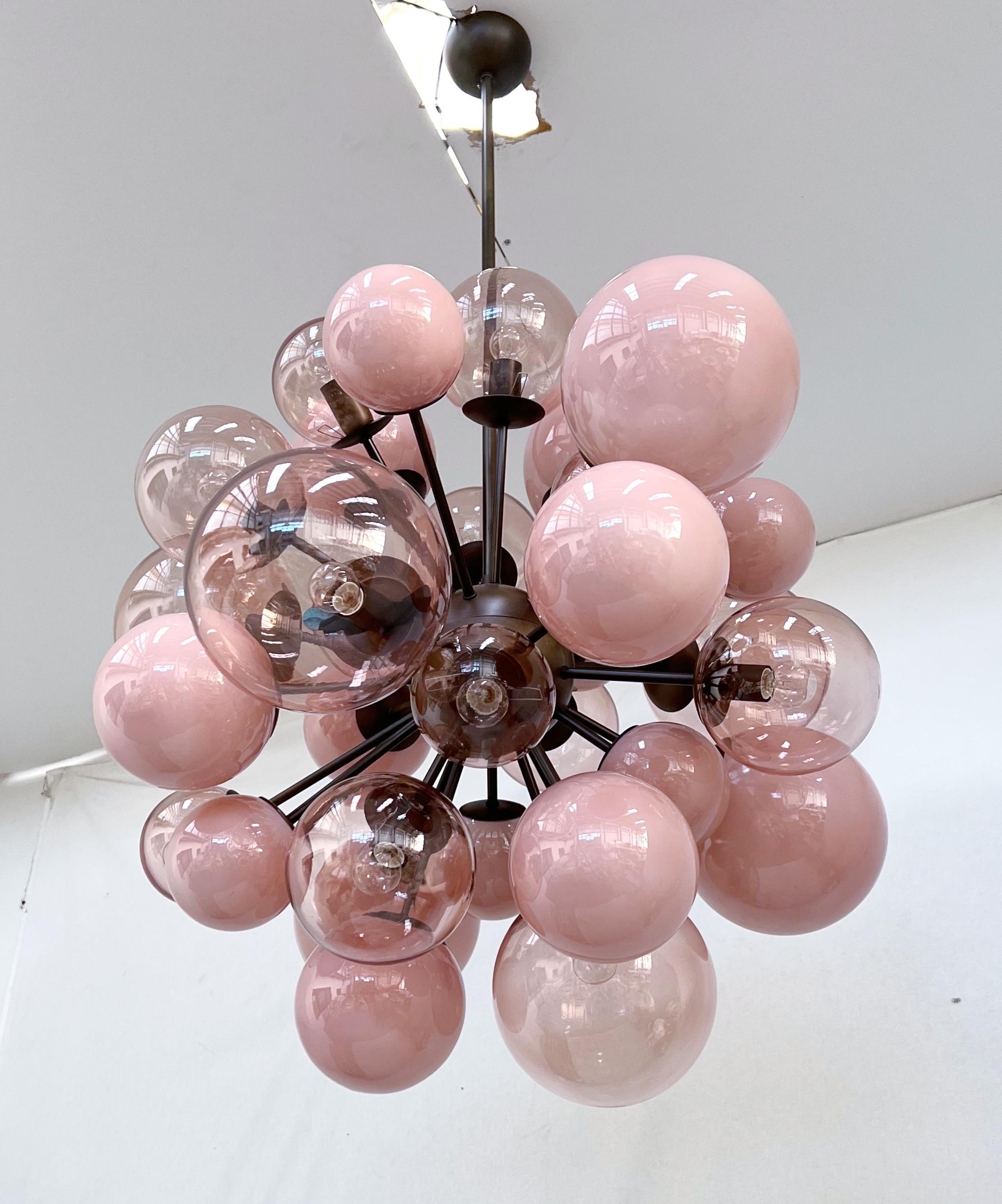 Lustre spoutnik italien avec 32 globes variés en verre de Murano dans des couleurs rose corail opaques et transparentes, montés sur une monture en finition bronze / Design by Fabio Bergomi for Fabio Ltd / Made in Italy
32 lampes / type E12 ou E14 /