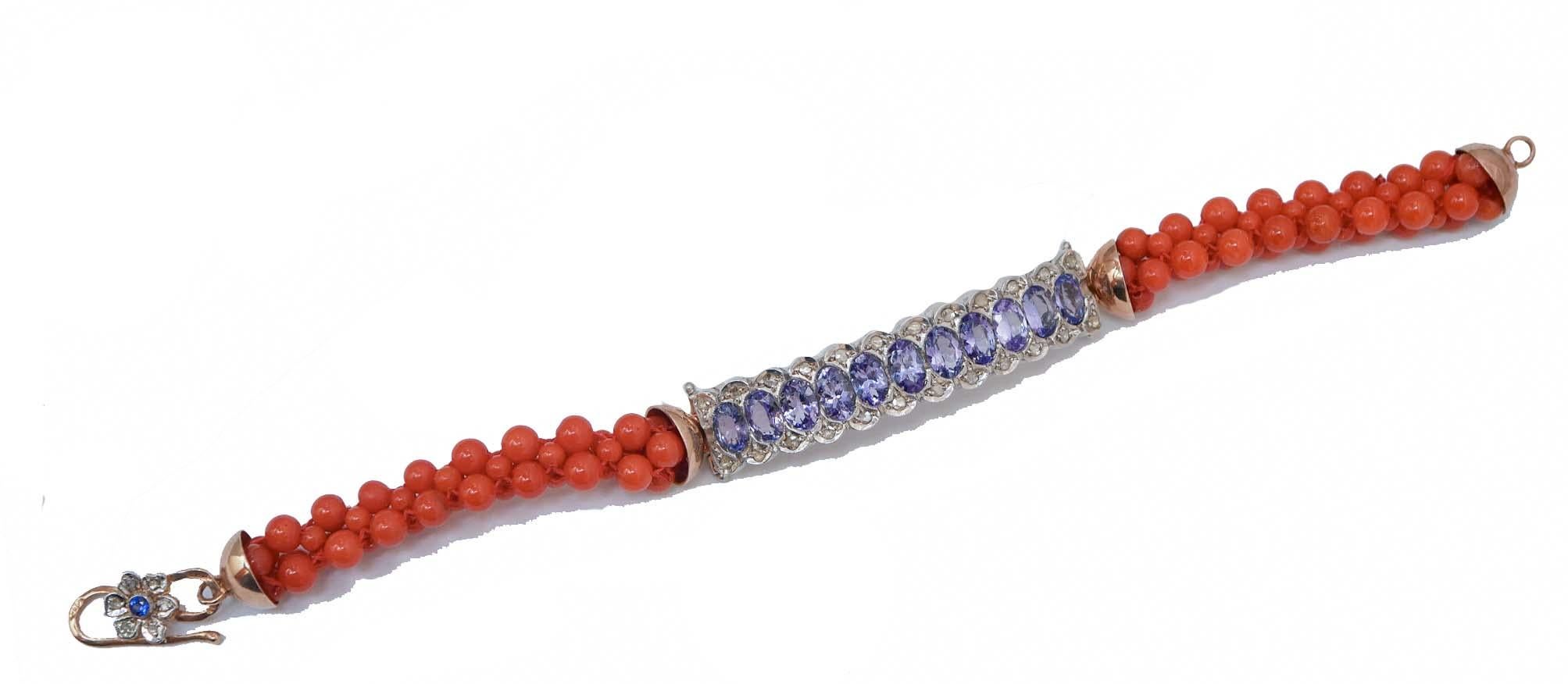 Superbe bracelet monté avec une structure centrale en or rose 9 kt et argent sertie de tanzanite et de diamants. Latéralement, des coraux. Comme fermeture, une fleur montée avec des diamants et une pierre.
Ce bracelet a été entièrement réalisé à la