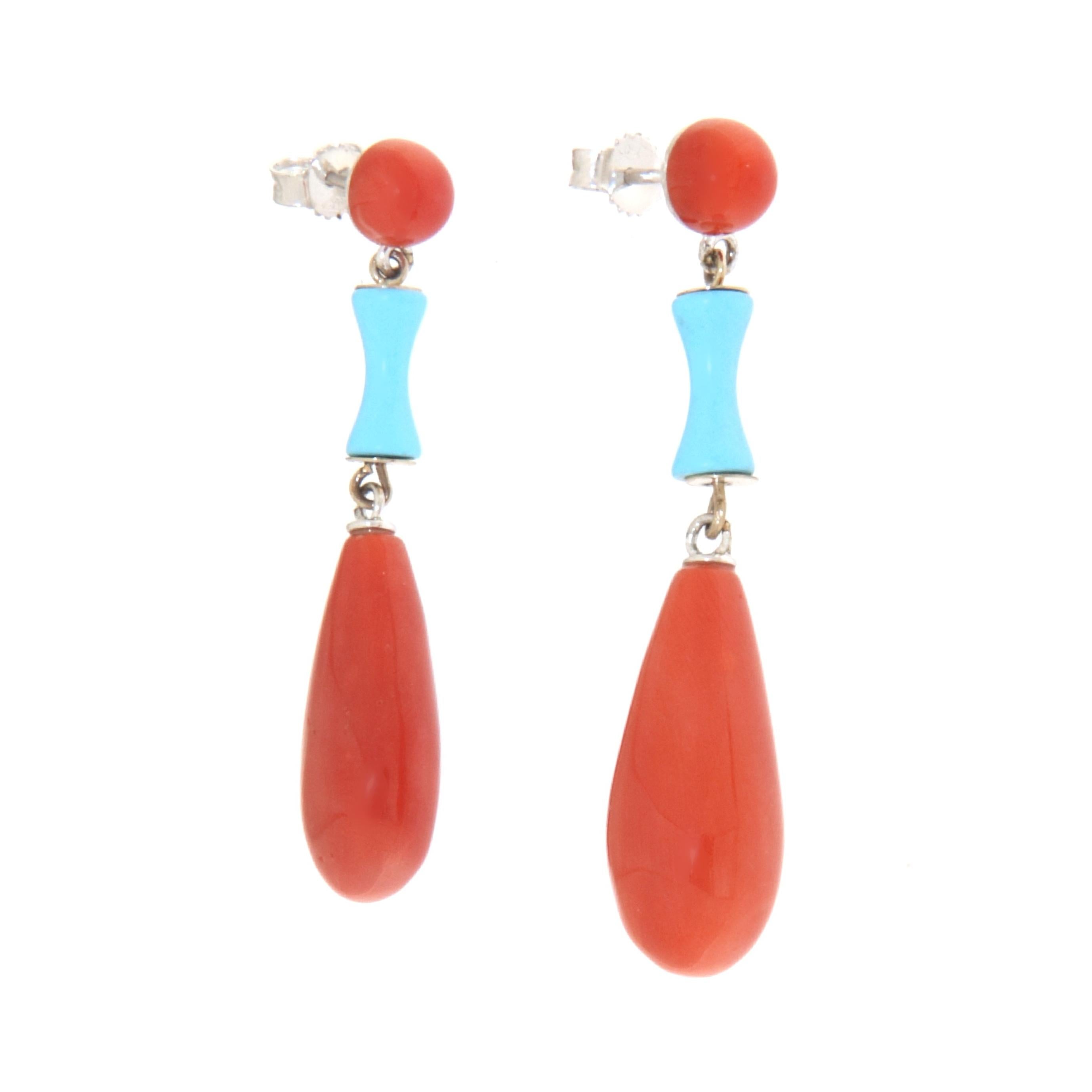 These elegant 18-karat white gold earrings represent a perfect combination of vibrant red coral and sky-blue turquoise, creating a refined and versatile accessory that adds a touch of color and luxury to any outfit. The choice of high-quality