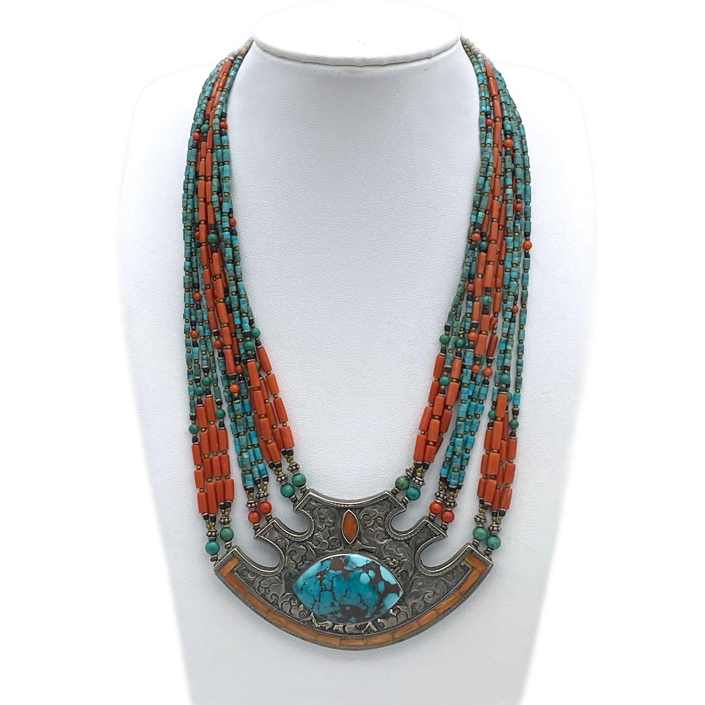This is a coral & turquoise multi-strand necklace. I bought this hand crafted Egyptian Revival necklace at a jewelry store in Istanbul many years ago. Twelve strands of small beads connect with a large vintage sculpted, patterned, bezel set and