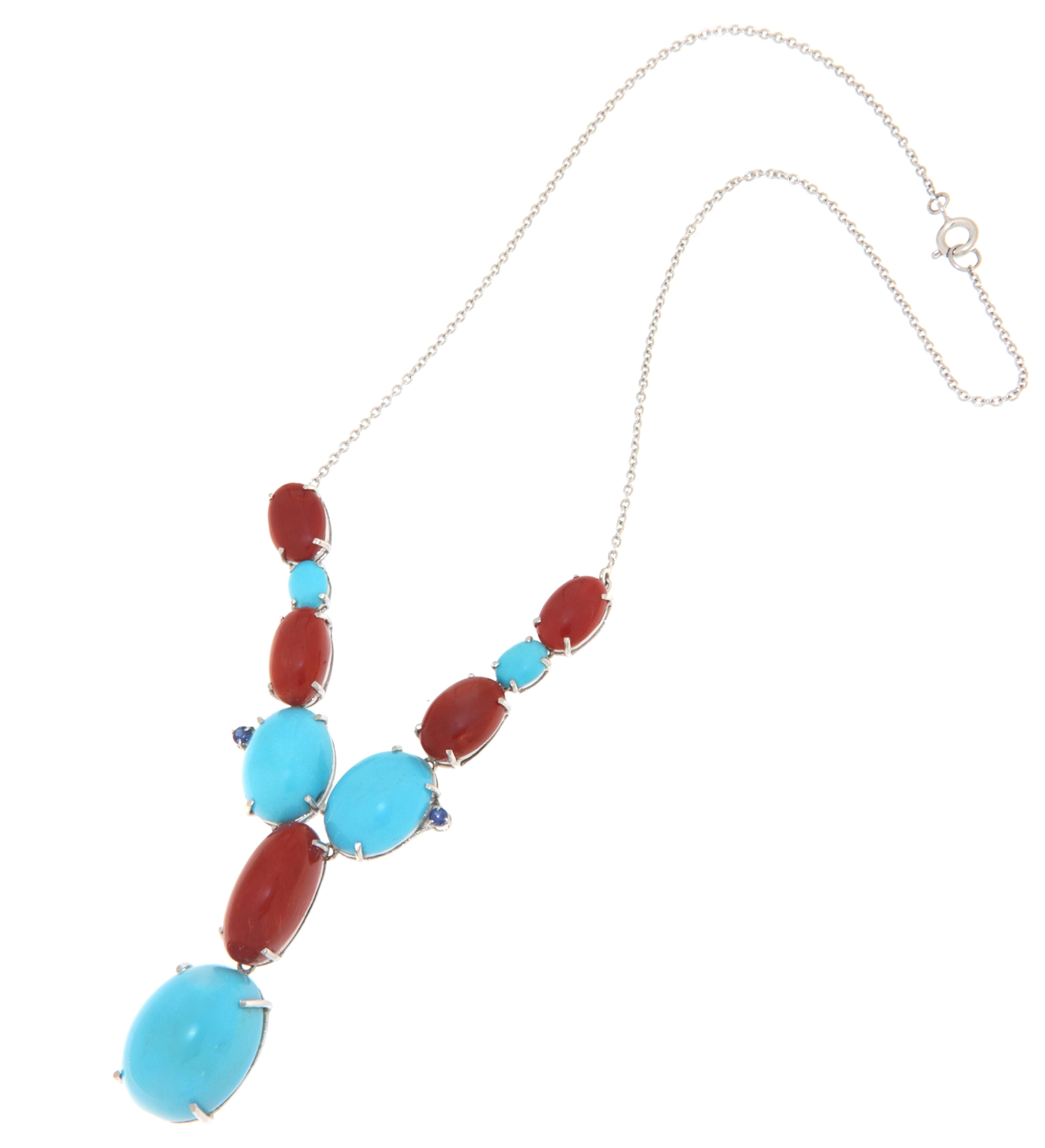 Necklace made entirely by hand in 18-karat white gold embellished with small sapphires and composed of ovals and spools of different sizes of natural red coral and turquoise.

A lively chromatic composition results from the mixture of these