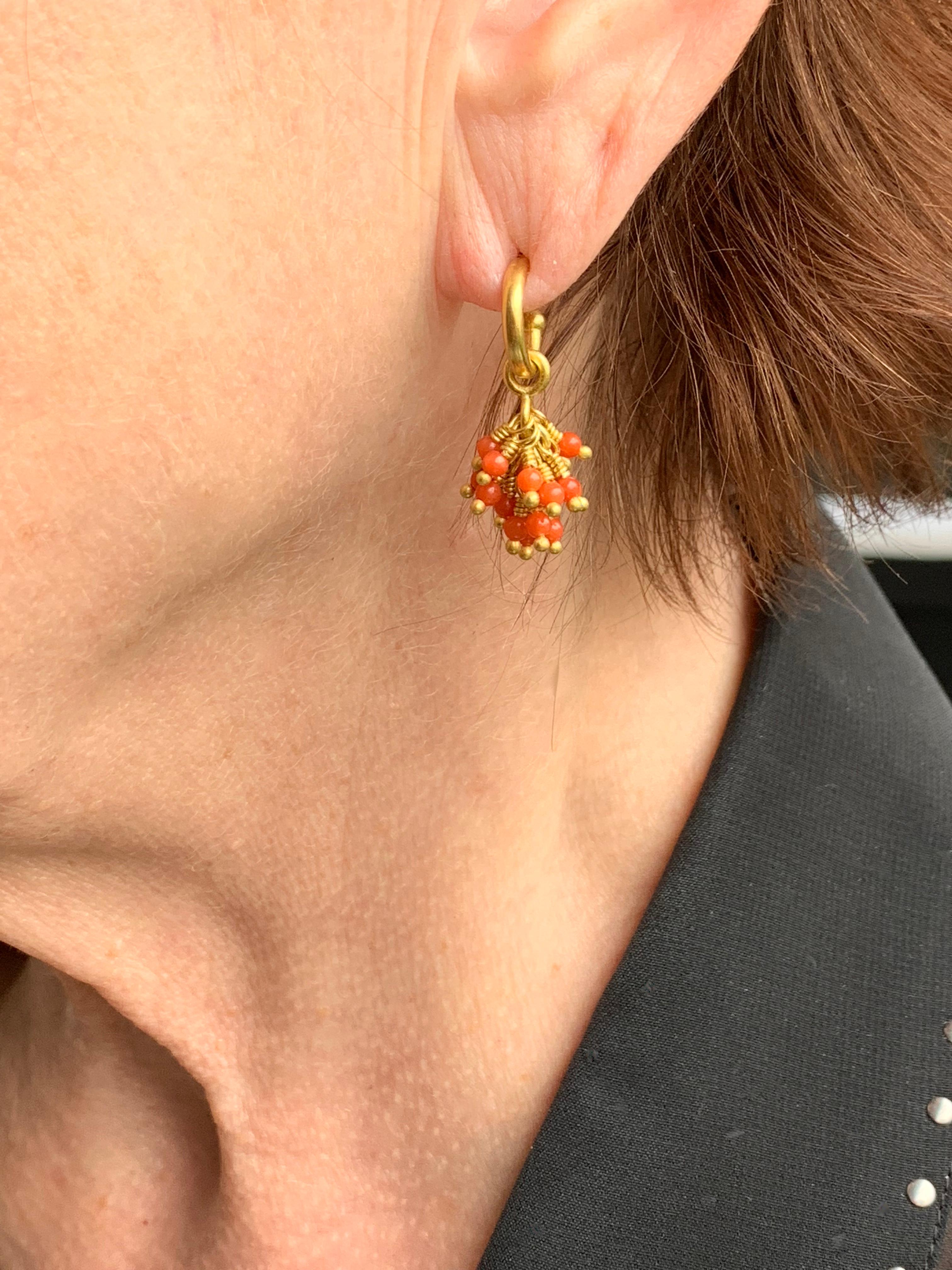 Natural Coral beads  drops and hoops in 22 karat gold. 18 karat posts and backs. These bright little bundles of color are fun and easy to wear.  Here on smaller size hoops .46 of an inch or 11.5 millimeters
Hand made in NY.