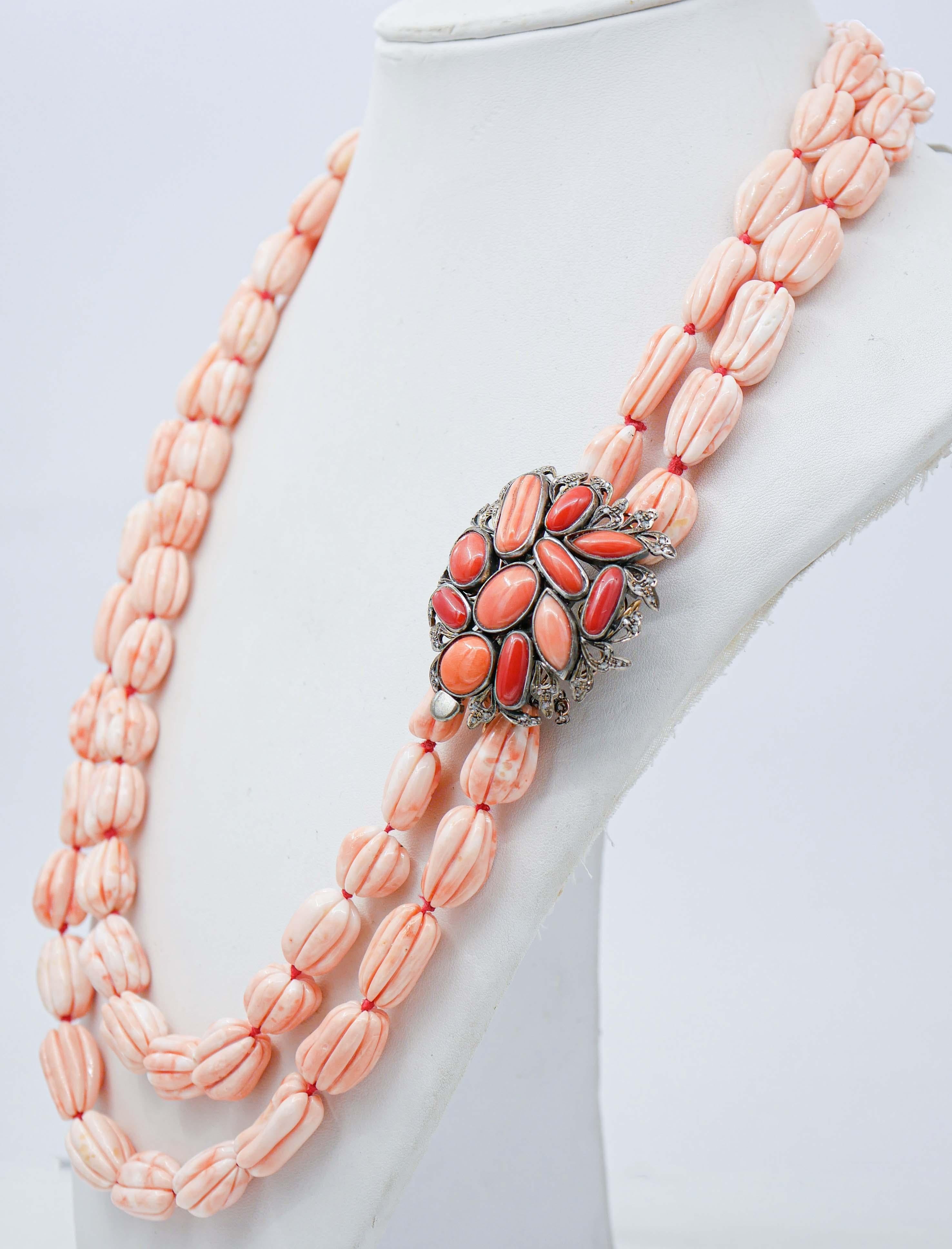 Wunderschöne Retrò-Halskette mit zwei Strängen aus rosa Korallen und einem Verschluss aus 9 kt Roségold und einer Silberstruktur mit Korallen, die von Diamanten umgeben sind.
Diese Halskette wurde von italienischen Goldschmiedemeistern in Handarbeit