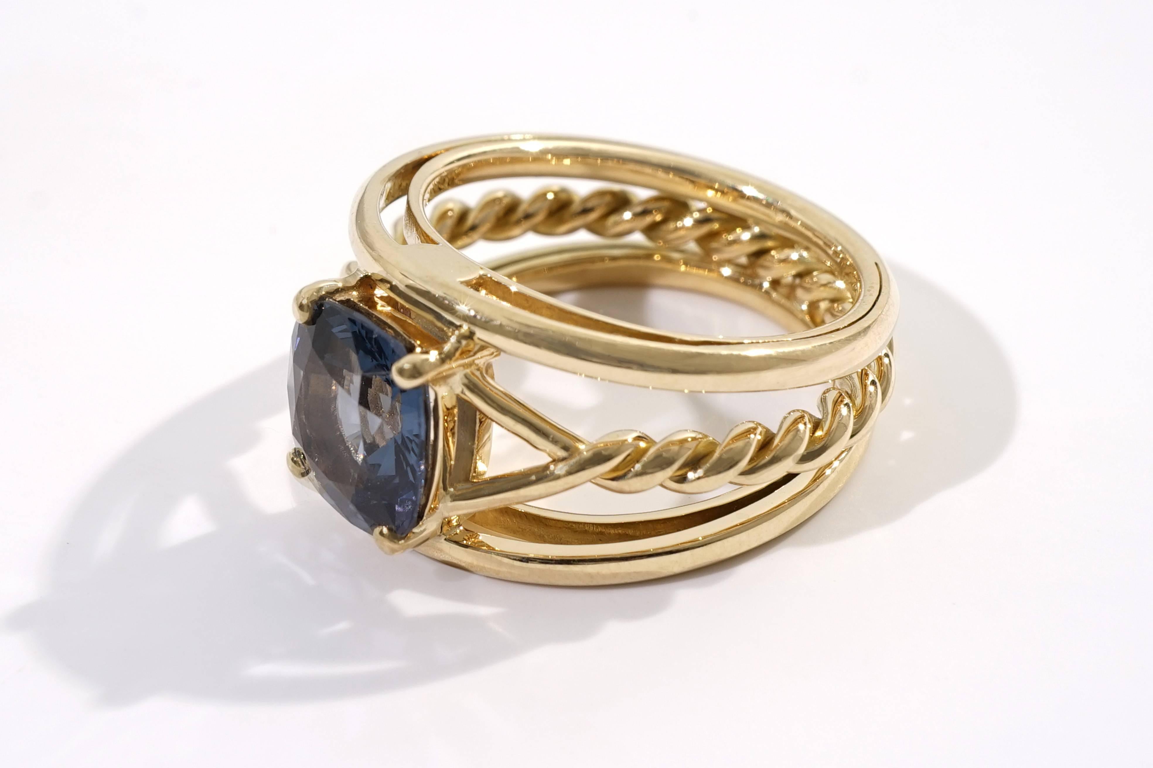 Coralie Van Caloen 18 Carat Yellow Gold Blue Spinel Band Ring is entirely hand made and forged in Belgium by experts goldsmiths therefore it is a very unique piece. The Spinel has a rare, natural blue colour and is mounted on an elegant 'torsade'