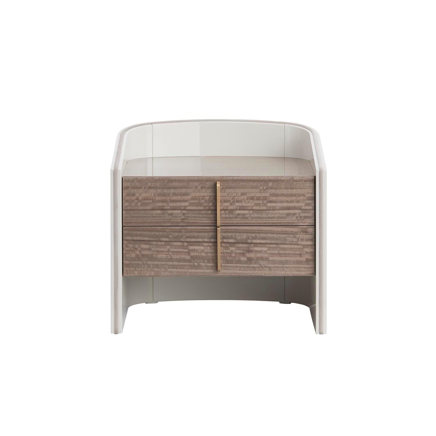 Elegant and sophisticated, the bedside table Coralina is characterized by a curved structure in lacquered finish, on which the drawers in veneered wood are inserted.‎ This bedside also allows the combination of different finishes between the curved