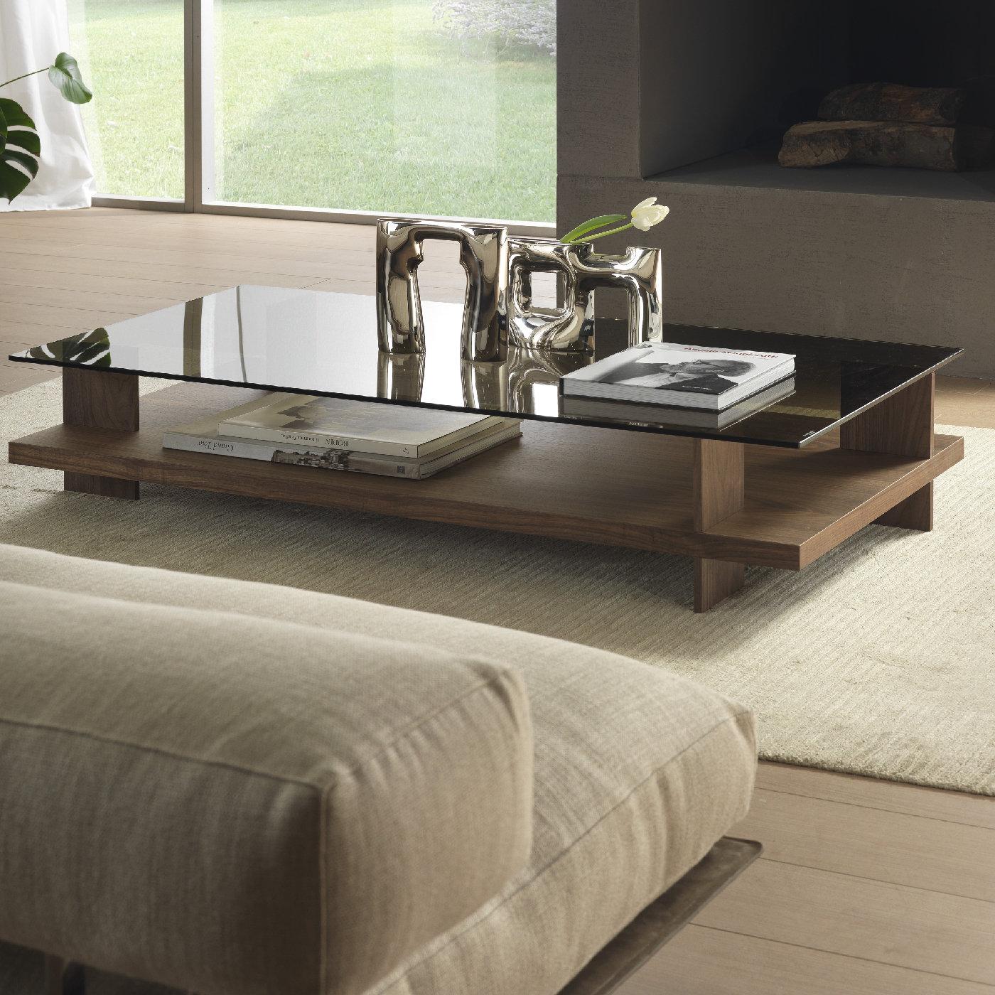 Part of the Corallo collection, this coffee table is both functional, as it provides two visible display surfaces and decorative, thanks to its solid yet harmonious silhouette and the use of natural materials. The upper top is in transparent-bronzed