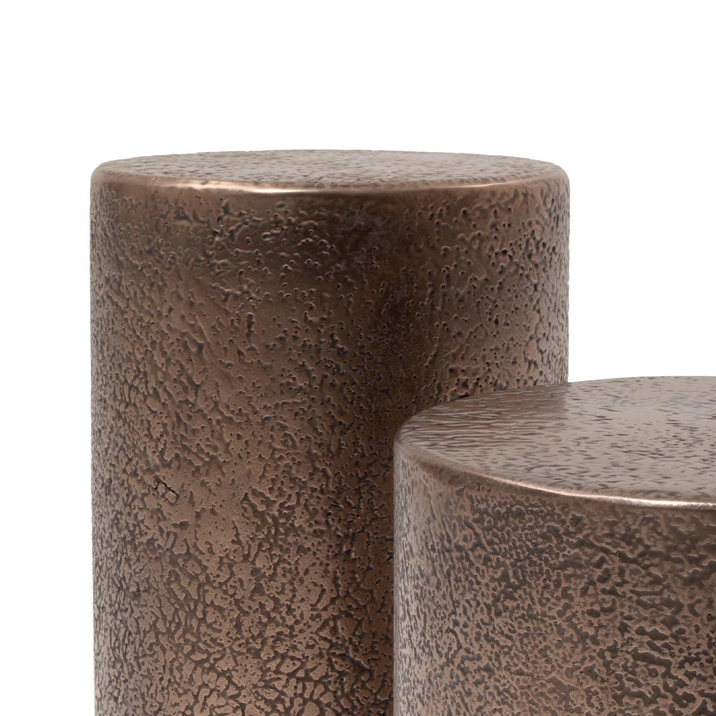 Discover this side table that gives a perfect addition to any modern interior. It counterbalances its cylindrical silhouette's simplicity with its embossed texture's dynamism. Realized in bronzed liquid metal, a combination lending the design