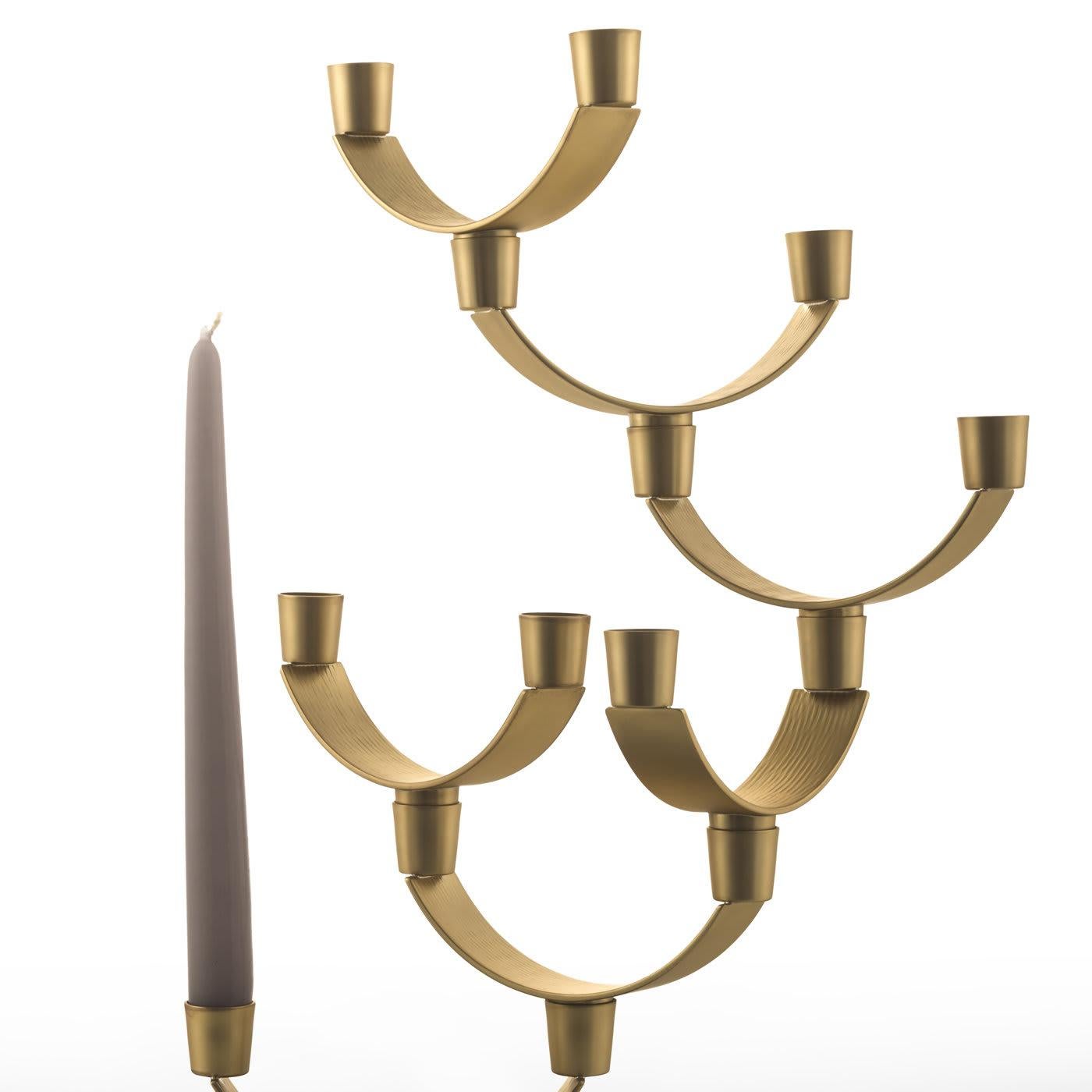 This striking piece is made entirely in brass with two different finishes: the rectangular base is bronzed while the seven semi-circular branches and mouths have a satin finish. The combination of these two hues and the geometric silhouette created