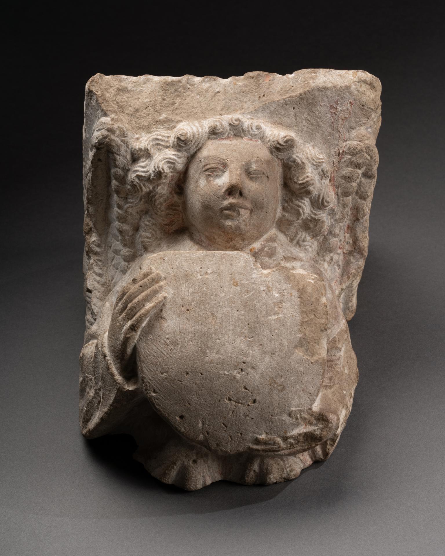 Corbel with an Angel Holding a Shield Franco-Flemish, Burgundian Netherlands 15th century Limestone
On a modern metal stand
H 21 x L 16,5 x P 18,5 cm
This finely carved stone corbel, dating to the 15th century, exemplifies the sophistication and