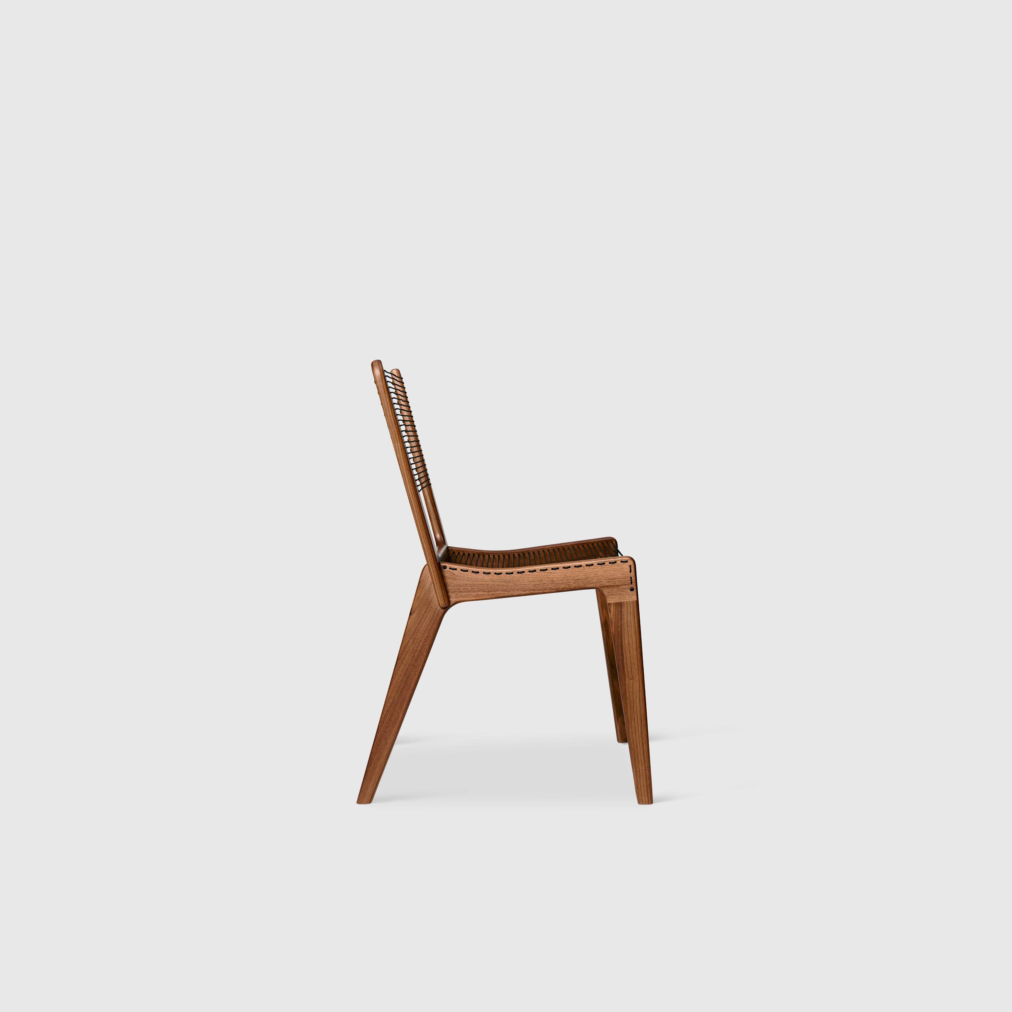 A Classic piece of Mid-Century Modern design, the cord chair was conceived in 1953 by Jacques Guillon. The chair’s wood frame in solid walnut is paired with cord that is tightly strung like a tennis racket, supporting a surprising amount of weight;
