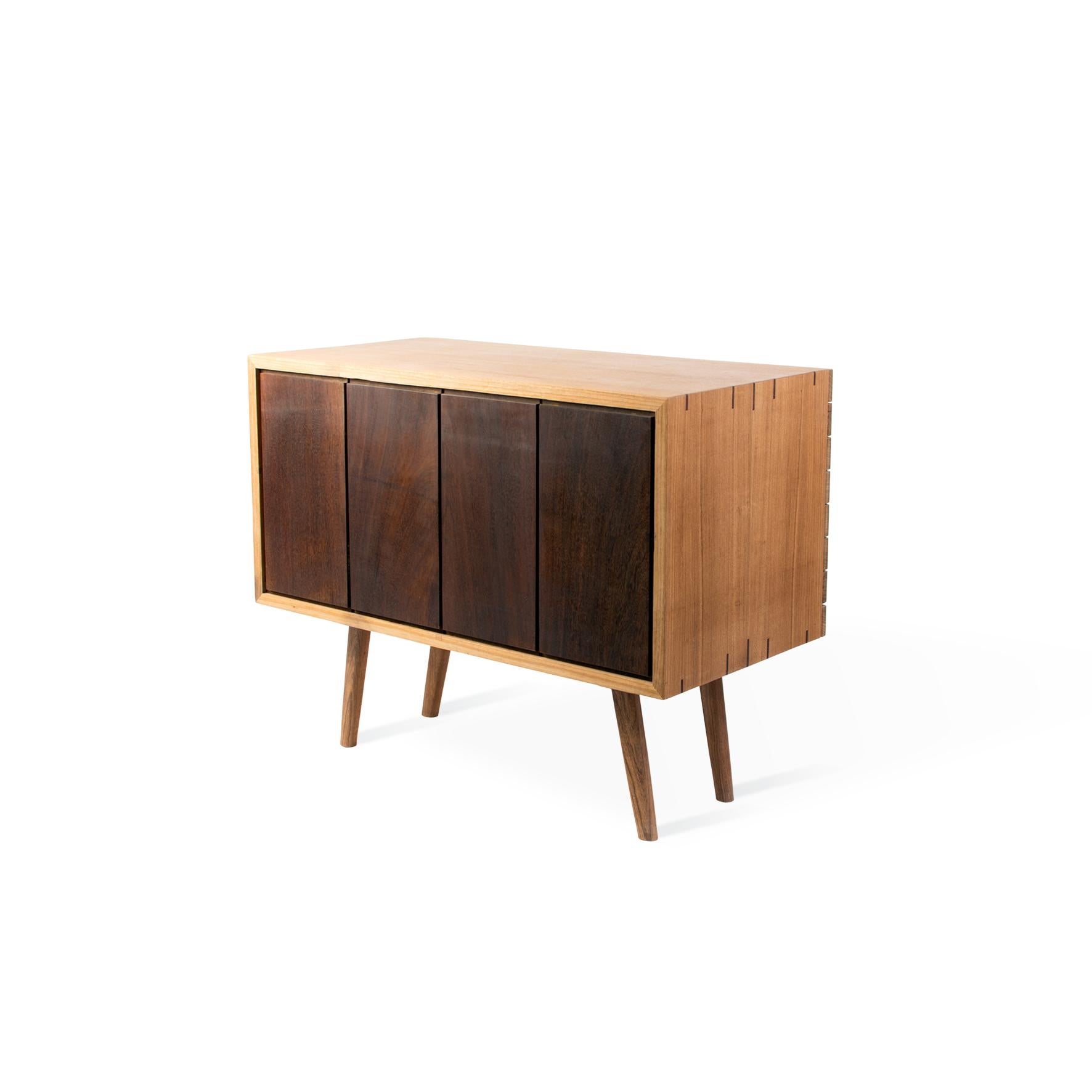 Cordilheira Cabinet was born as an idea to divide two spaces, it has a subtle curve on the front, and the often forgotten rear receives its own design with a dark contrasting tone. The mid-century modern design includes delicately undulating doors