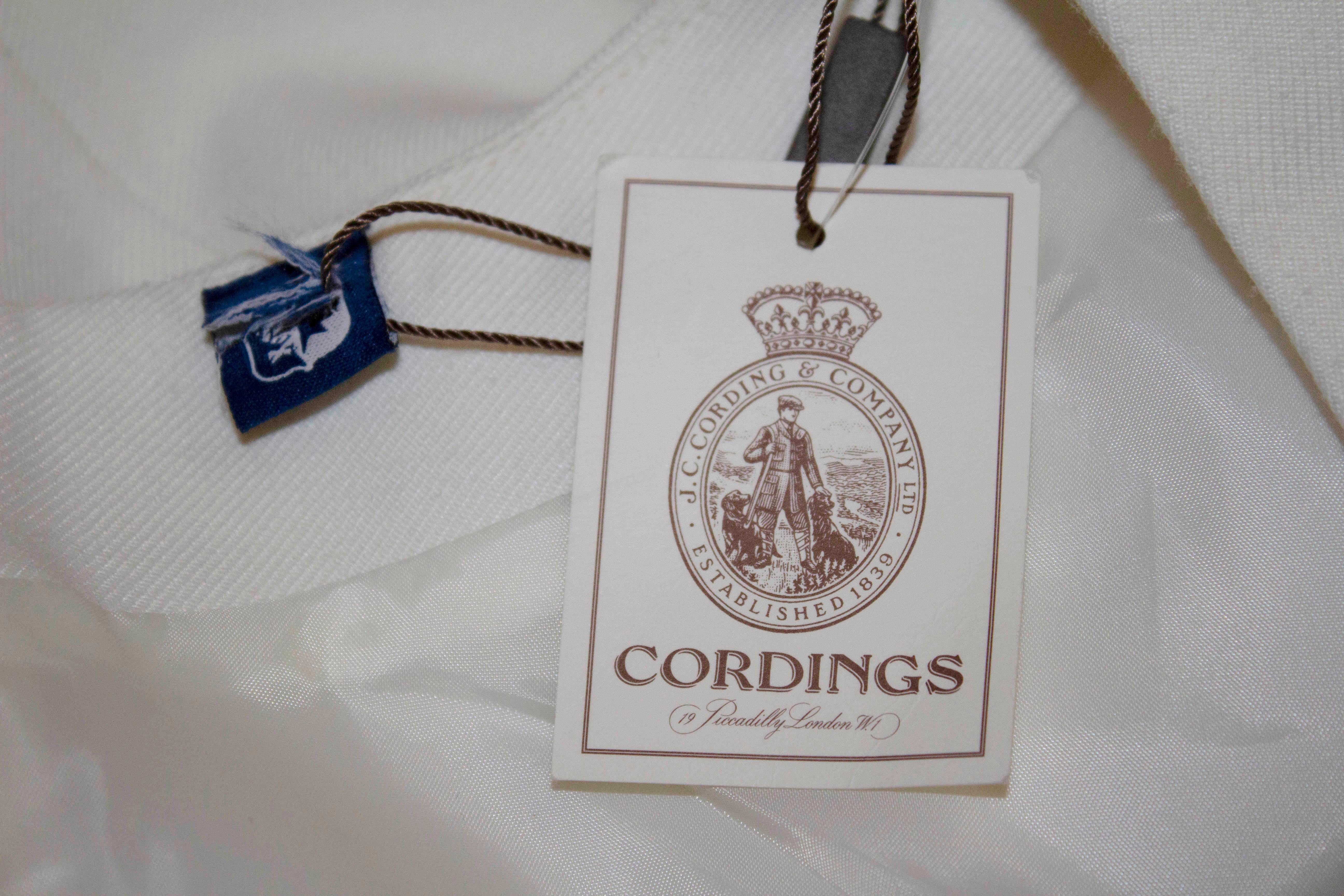 A white dress by Cordings, the dress is in a cotton /wool mix with a scoop neckline and v front , fully lined with a back central zip. Measurements:  Bust 36'', length 40''