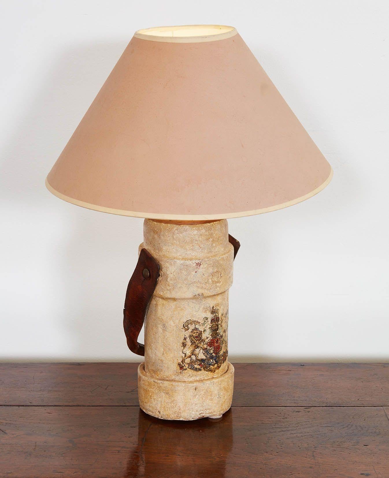 English early 20th century leather and oil cloth cordite or shell carrier, having leather strap handle and original Royal crest decal on an ivory white ground, now as lamp.