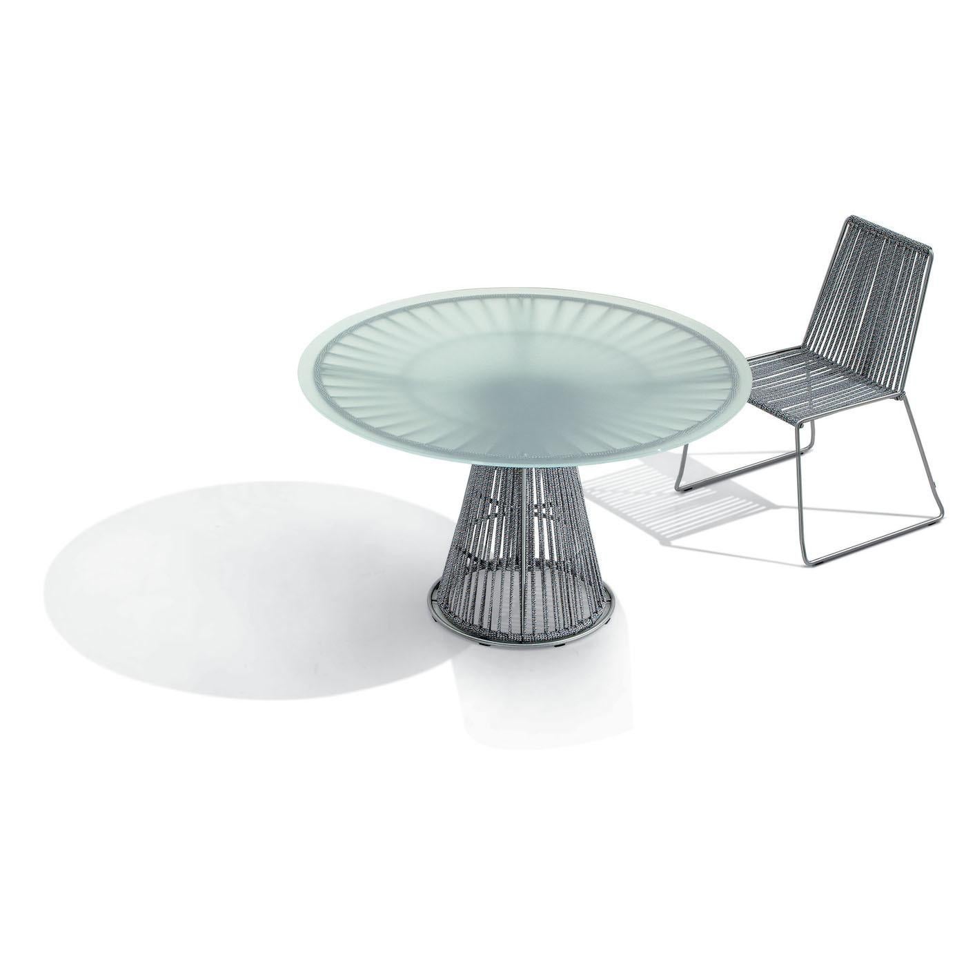 Crafted entirely of stainless steel rods with brushed finish, this stunning dining table makes a dynamic style statement in a modern and Industrial-inspired dining room. The cone-shaped column and the base under the tabletop are composed of strings