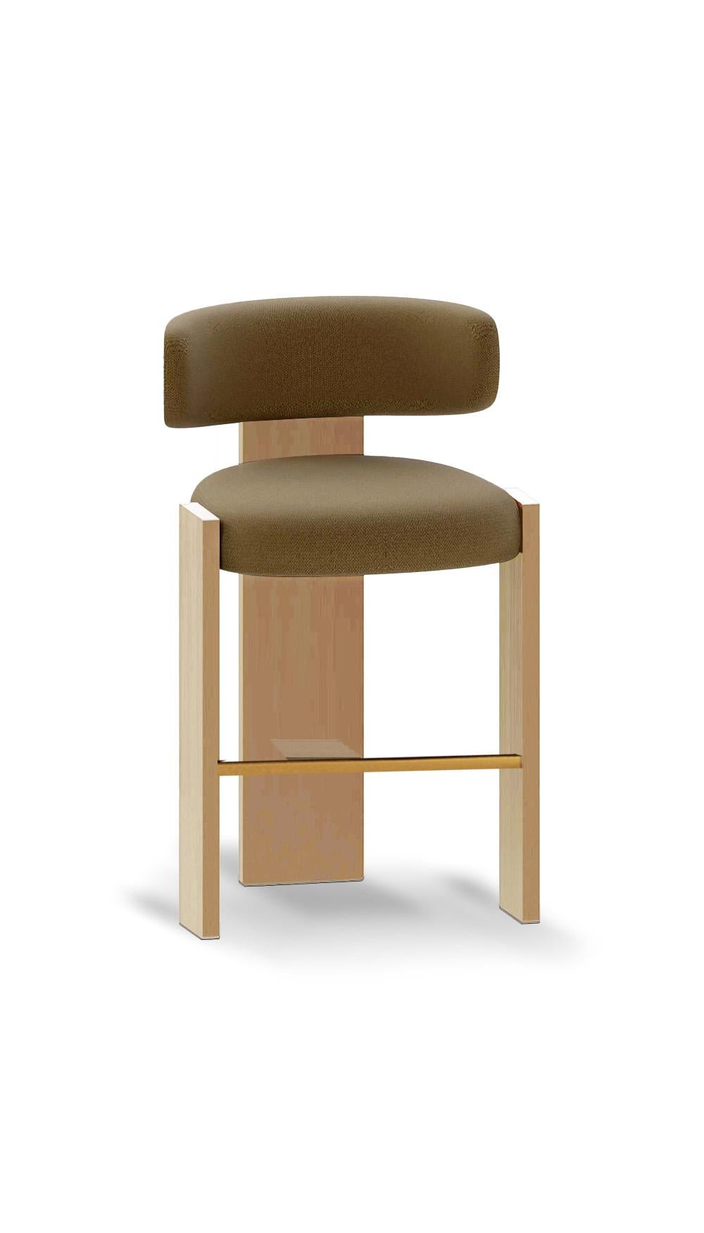 La sedia da bar Core unisce il rigore architettonico alla morbidezza scultorea. Con la sua robusta struttura geometrica in Oak e lo schienale imbottito dolcemente curvo, offre struttura e comfort. Il dettaglio del poggiapiedi in ottone aggiunge un