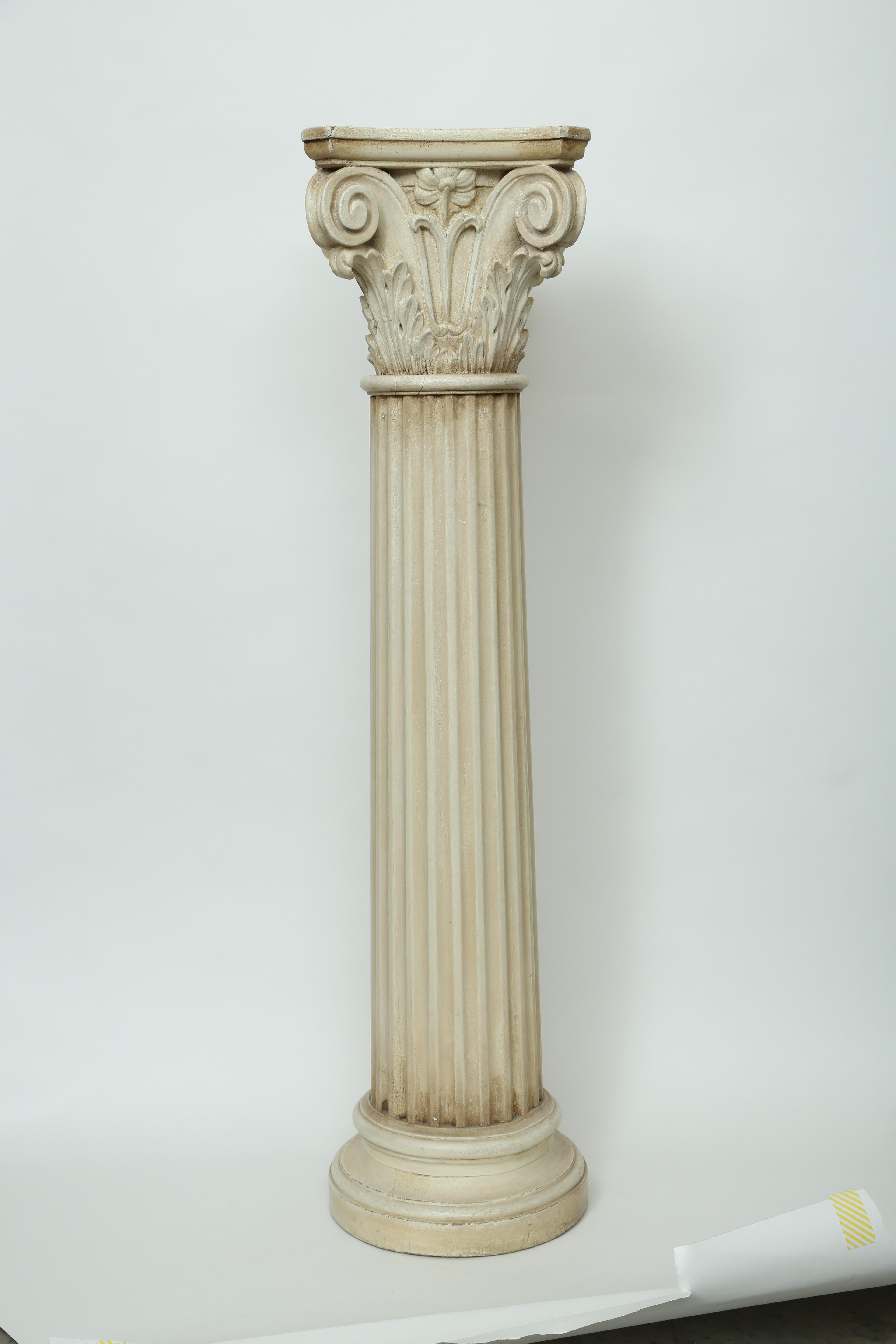 Painted 19th century Corinthian capital wood pedestal. The Corinthian capital has a cut corner top placed on a fluted column all of which sits on a turned round base.