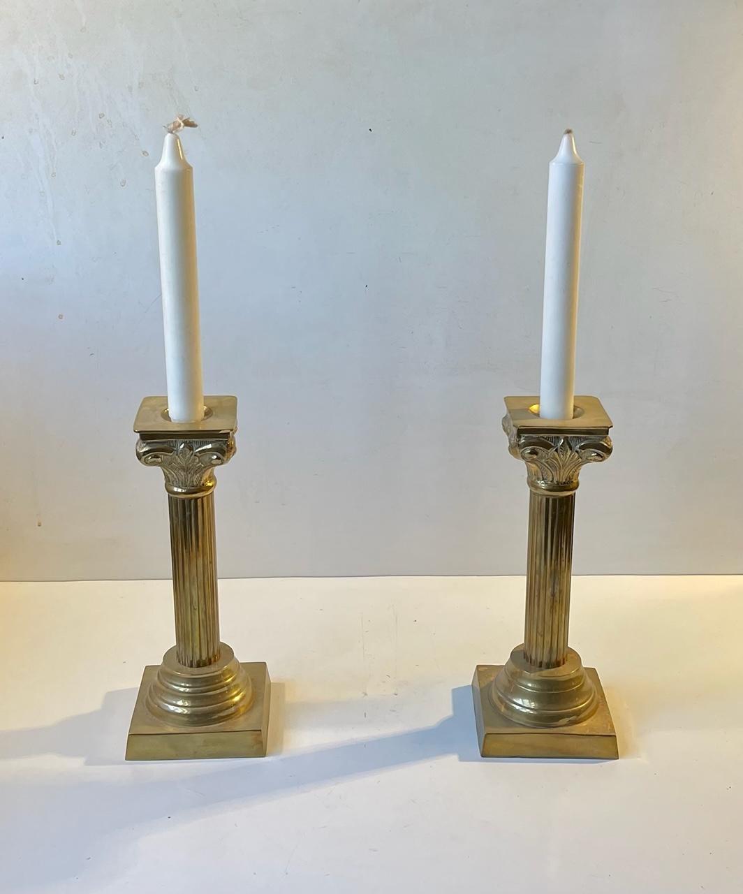 Ein passendes Paar von Kerzenhaltern im neoklassizistischen Stil. Sie sind aus massivem Messing gegossen und als korinthische Säulen geformt. Unbekannter europäischer Hersteller, ca. 1970-80. Sie sind mit Kerzen in normaler Größe zu bestücken.