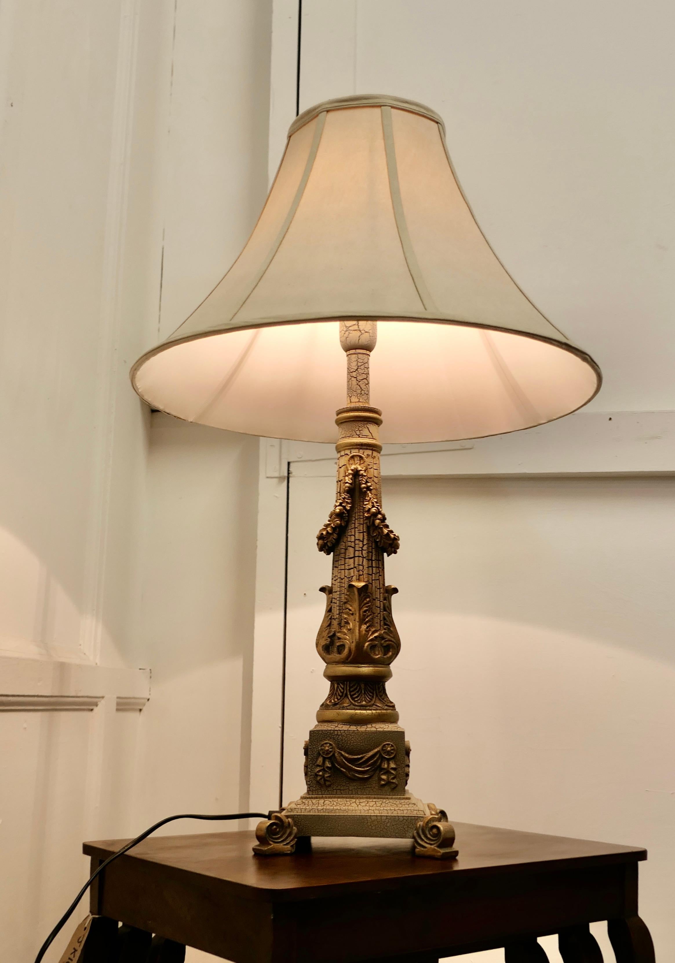 Corinthian column table lamp

This is a very attractive piece the column is decorated with swags and acanthus leaves and is set on a stepped and scroll footed base, the lamp has a crackle patinated finish which resembles old brass
This is a very