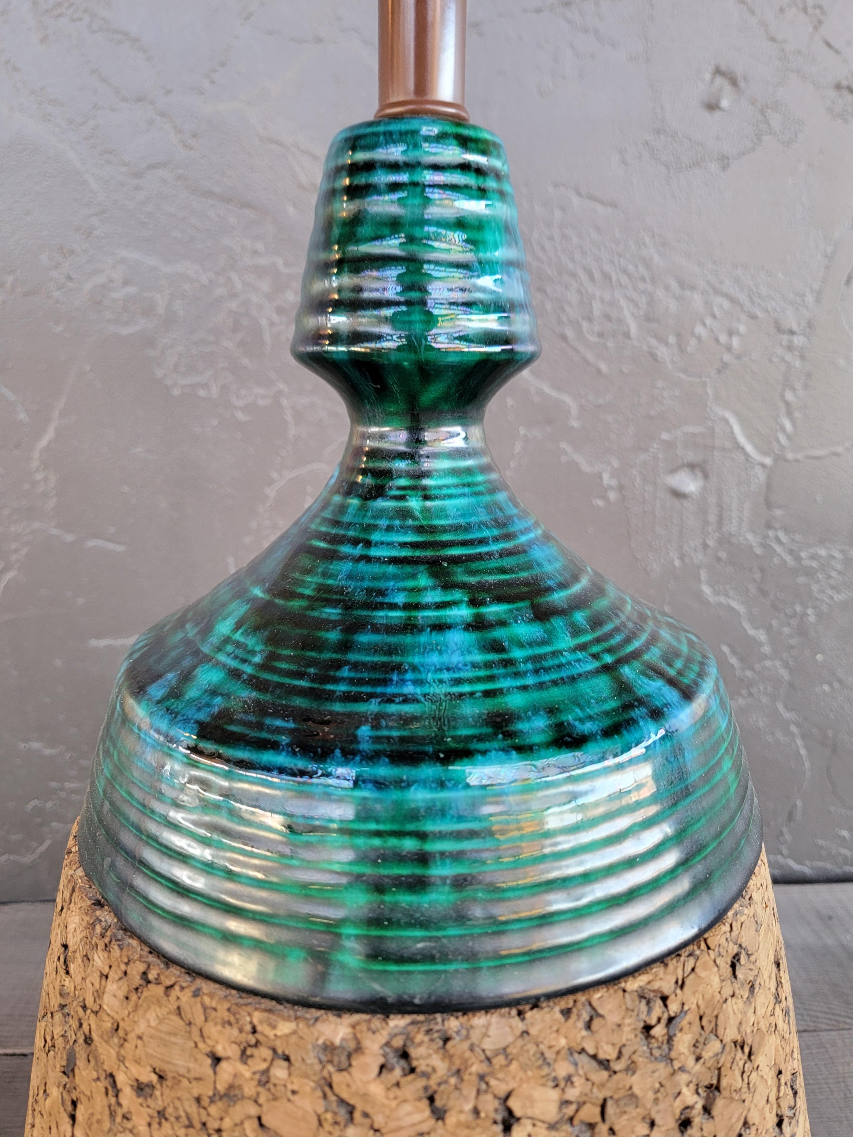 Unusual combination of cork and ceramic on this 1950's Mid-Century Modern table lamp. Mottled or drippy glaze in shades of blue and turquoise over a cork base with a brass plated plinth. Very good original working condition. Offered without