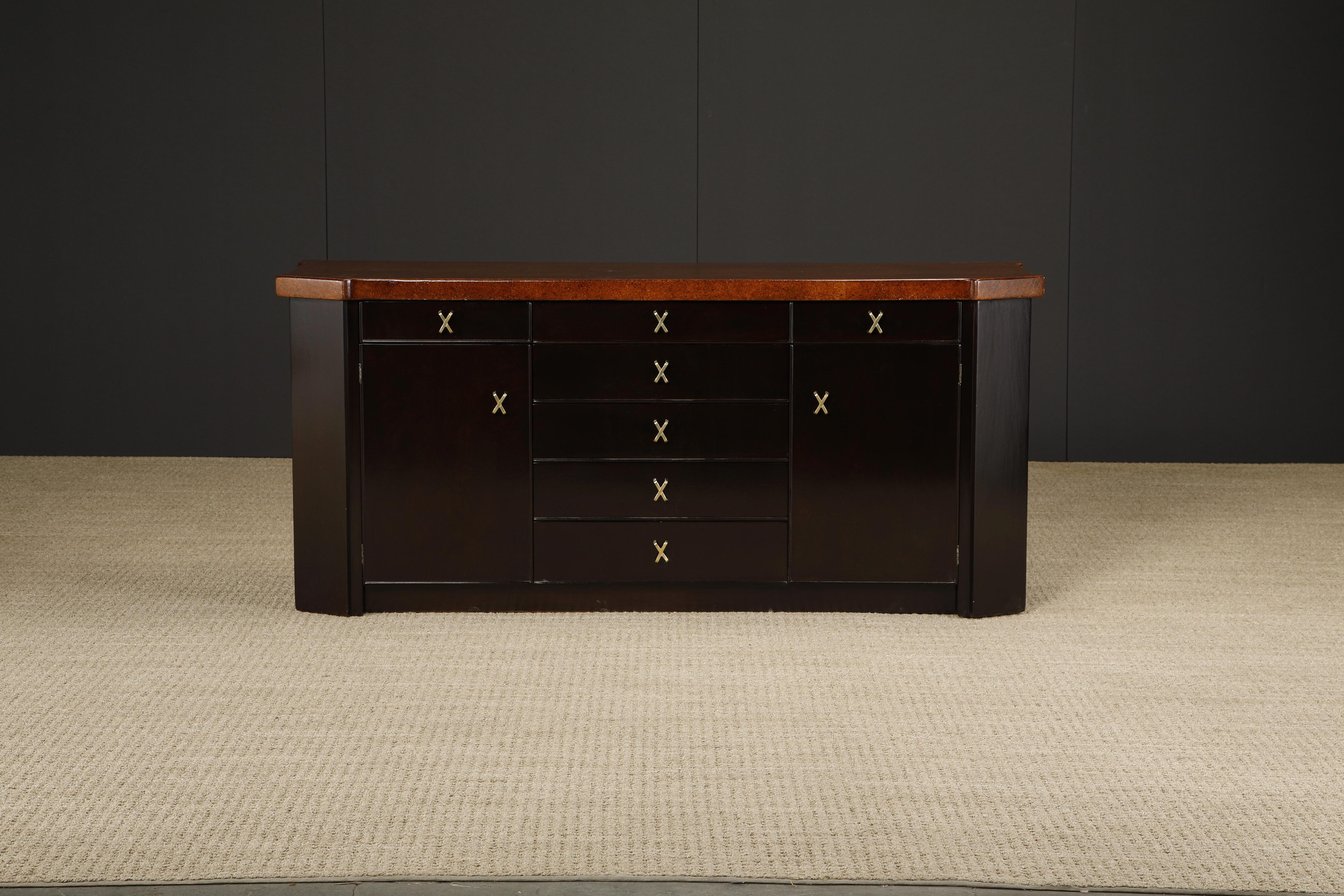 This restored Paul T. Frankl for Johnson Furniture sideboard cabinet or dresser, circa 1950s, features beautiful refinished Mahogany and cork with brass x-shaped pulls and is signed with Johnson Furniture Co stamp and paper label on inside