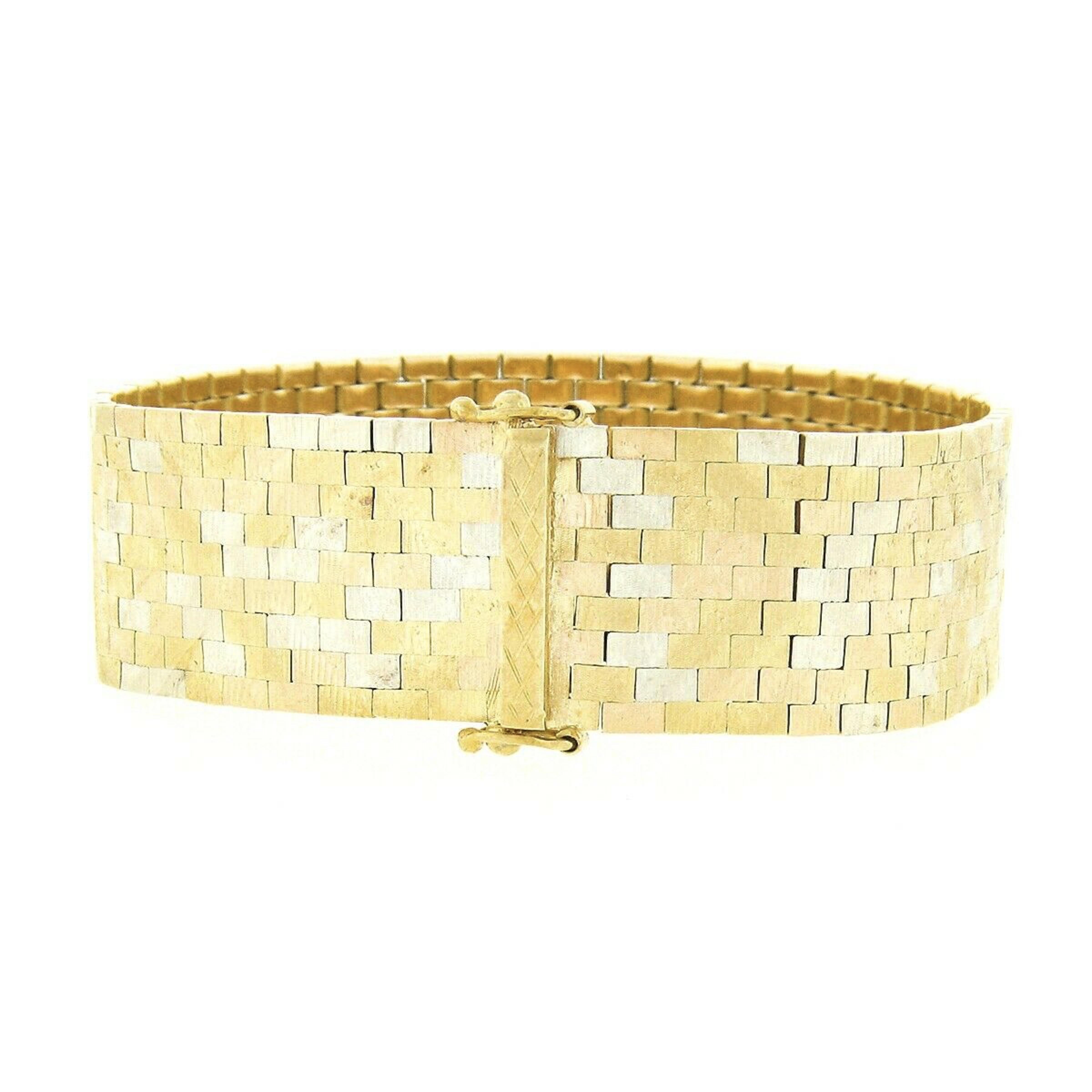 This gorgeous strap bracelet was designed by Corletto and crafted in Italy from solid 18k yellow gold with white gold accents featuring links set in a unique brick pattern with a wonderful textured finish throughout. The links come together on this