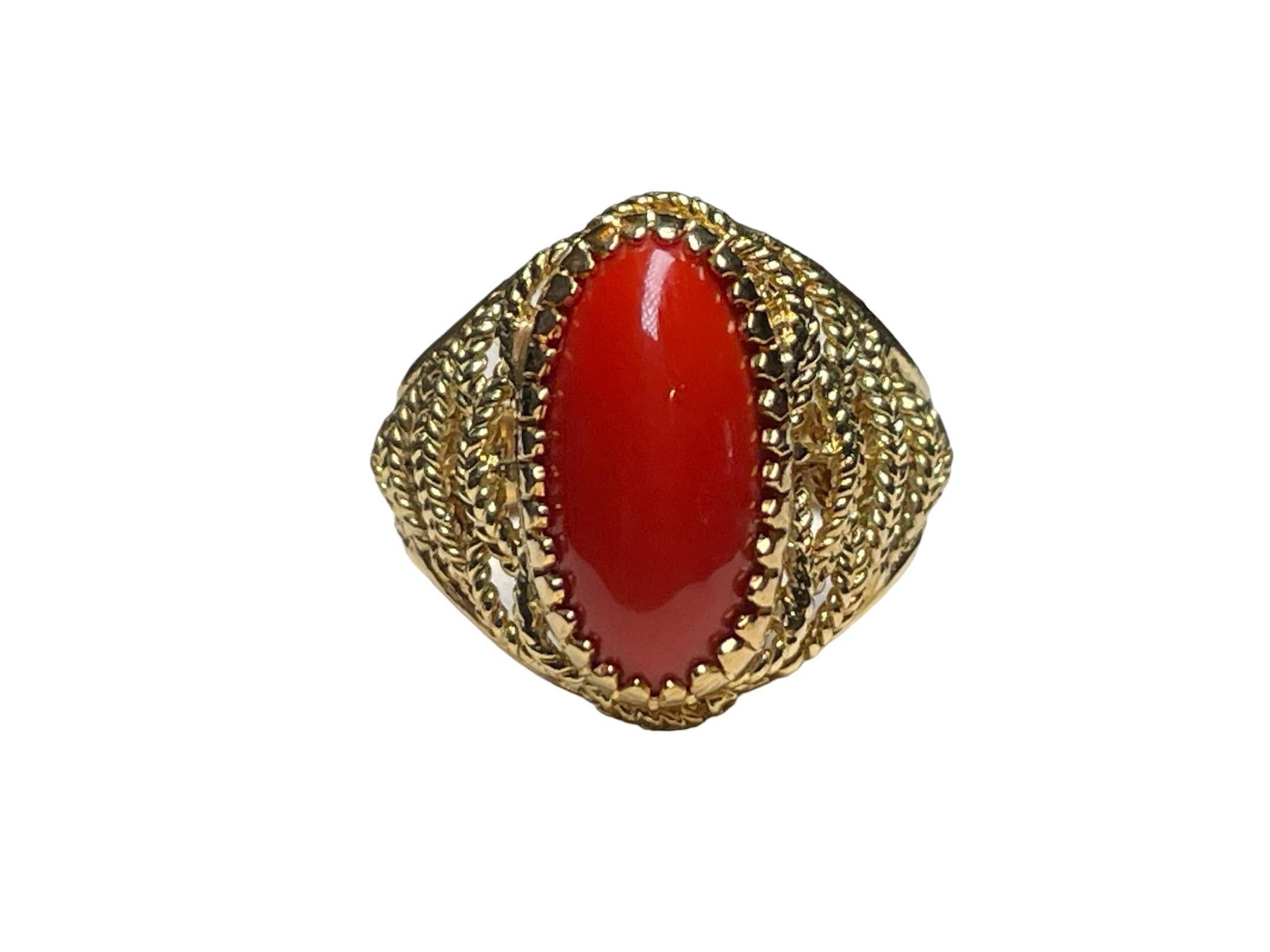 Questo è un anello da cocktail Corletto in oro giallo 18 carati e corallo. Raffigura un corallo rosso cabochon di forma ovale montato in una montatura d'oro con punte su una cupola ornata da corde d'oro intrecciate. La larghezza e la lunghezza del