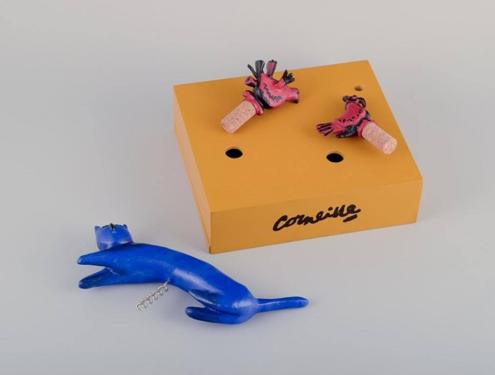 Corneille, artista Cobra. Set da vino scultoreo realizzato in legno e resina.
Gatto blu (cavatappi) e due uccelli rossi (montati su tappi di sughero).
Dal 2006.
Contrassegnato: Corneille.
Numerato: 528/999.
In buone condizioni, con una piccola crepa