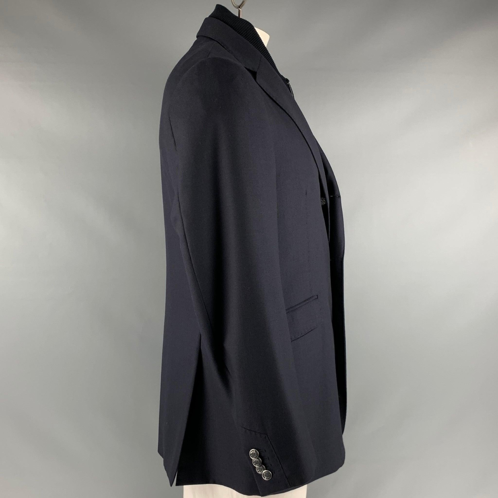 CORNELIANI
jacket in a navy virgin wool fabric featuring a single breasted style, three pockets, removable zip up inner lining, and three button closure. Made in Italy. Very Good Pre-Owned Condition. Minor signs of wear. 

Marked:   52