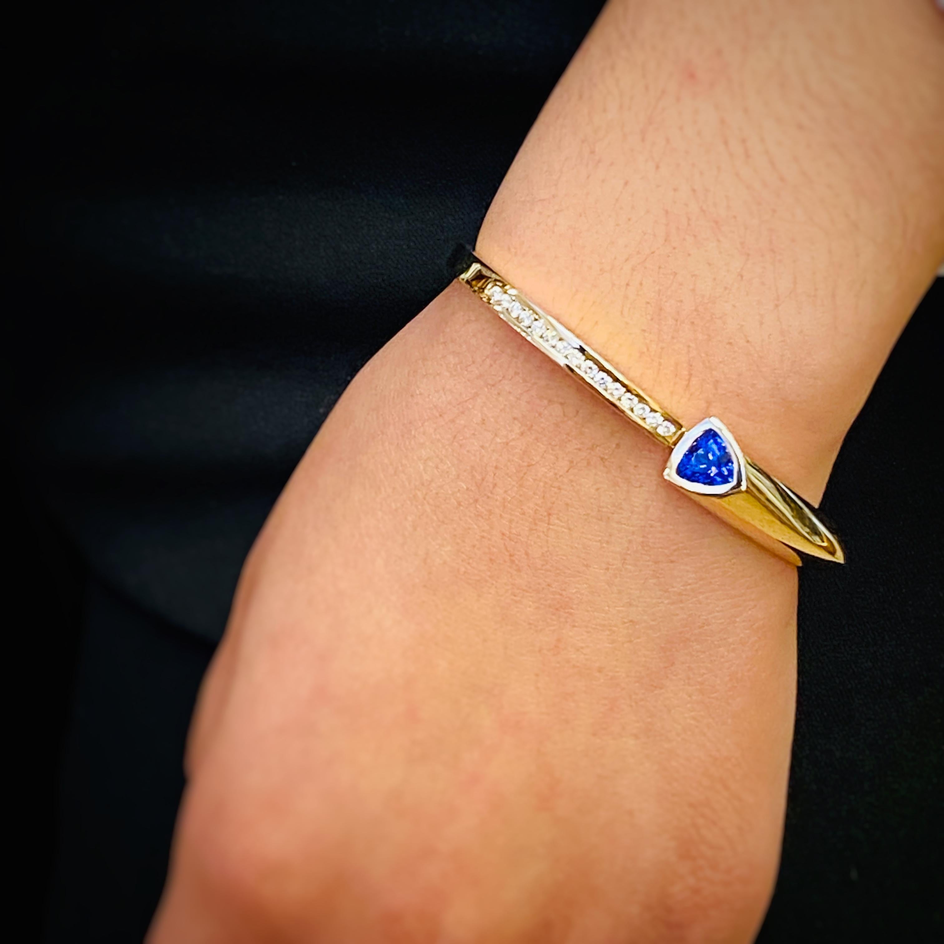 A single, trillion, beautifully colored Tanzanite is featured in this high polish, 14k gold bracelet by Cornelis Hollander.  Diamond pave accents the other side of this hinged bracelet.
New, never worn condition.
Tanzanite approximately 2