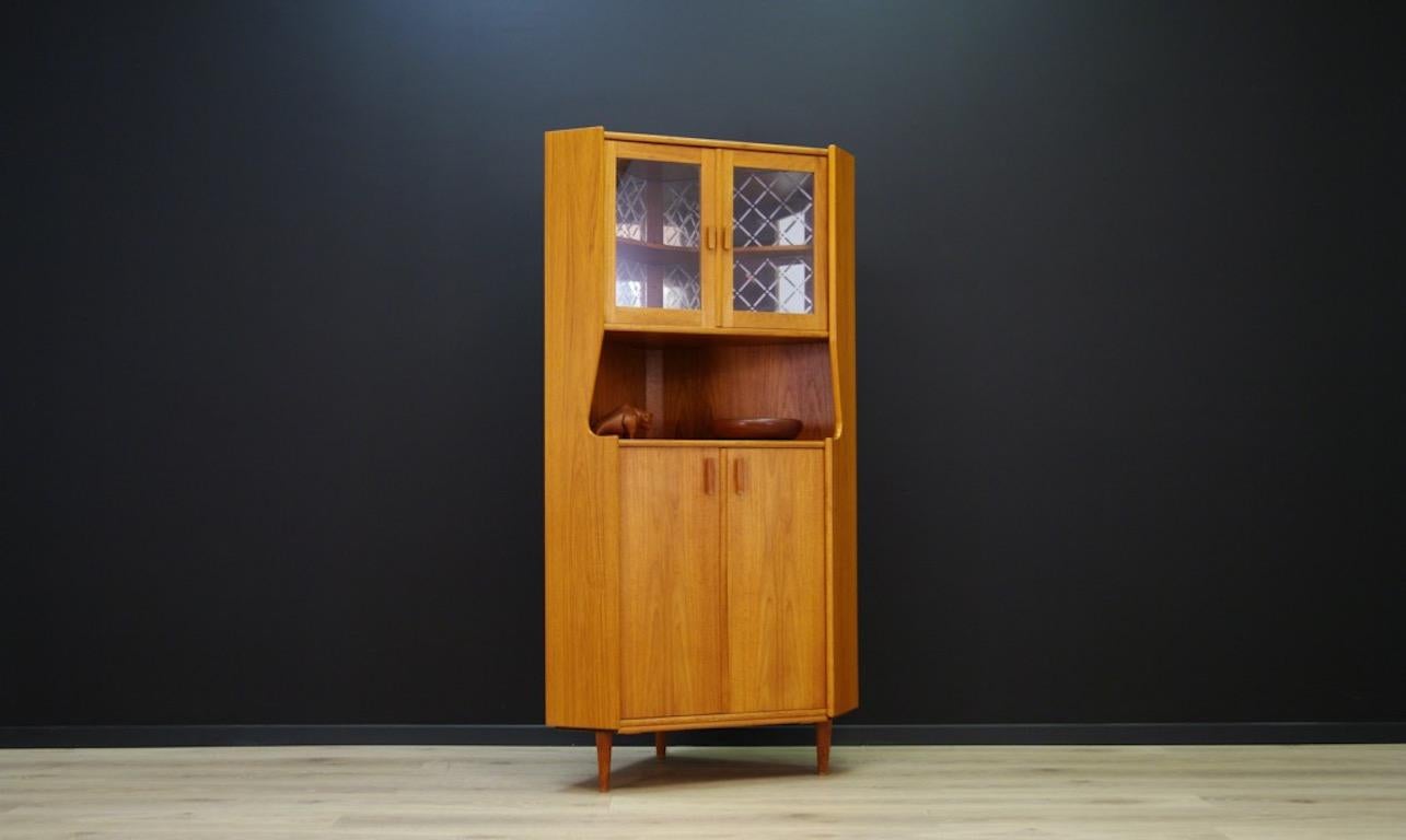 Stylish corner cabinet from the 1960s and 1970s, Danish design, cabinet finished with teak veneer. Behind the glass doors a shelf and a decorative mirror. In the lower section a roomy space with two shelves. Preserved in good condition (small dings