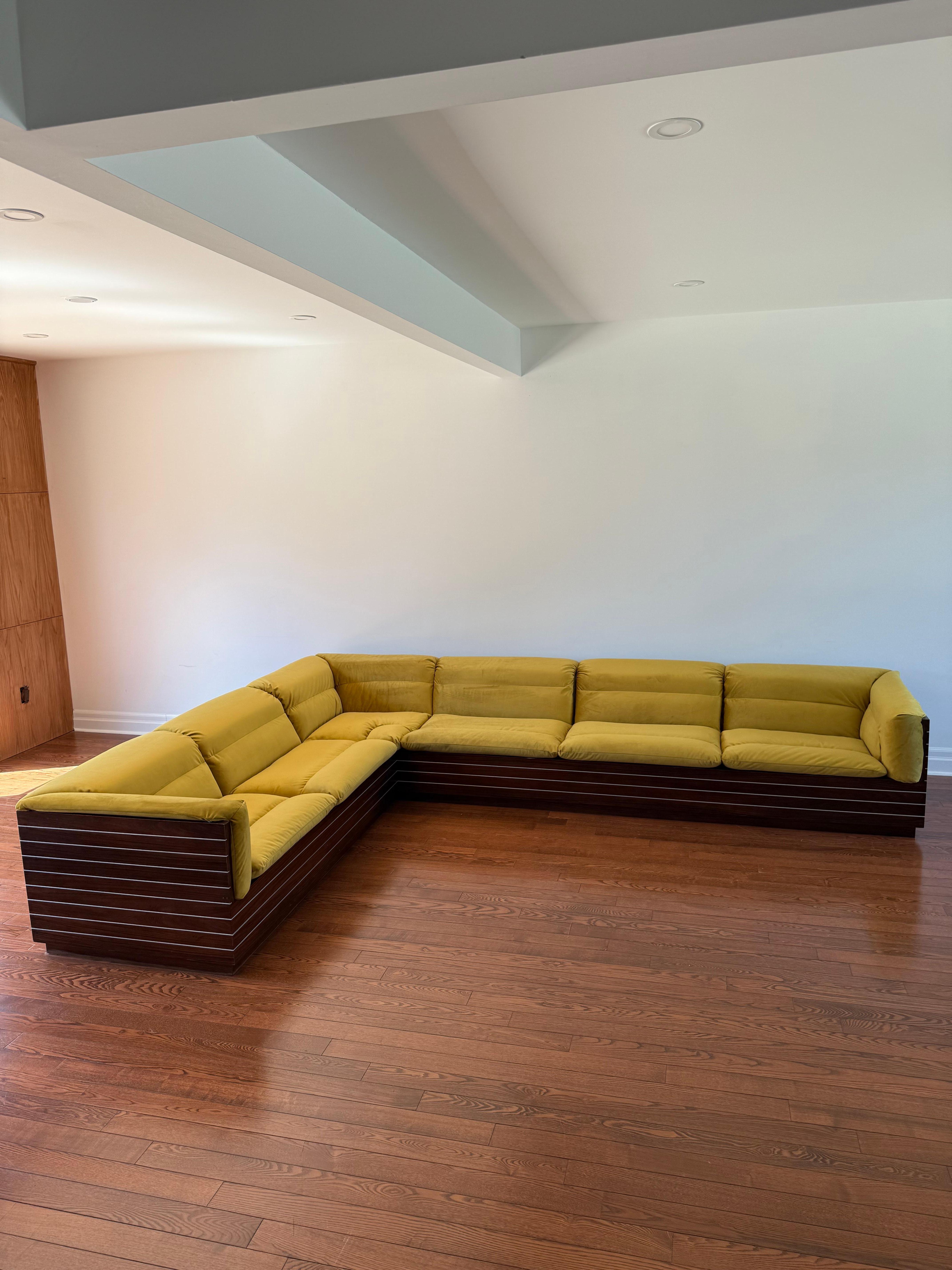 Design care of Giovanni Offredi for Saporiti. Italy, 1970s. Wood casement frame with horizontal metal inlays wrapping the entire perimeter. Makers marks visible on interior of frame. Reupholstered in a golden green velvet polyester fabric with a