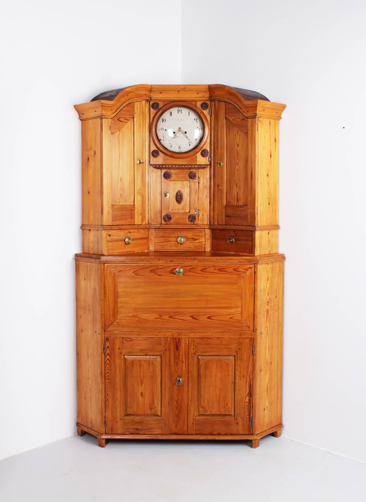 Antique corner cabinet with built-in grandfather clock

Sweden
Pine
Classicism around 1800

Dimensions: height: 220 cm 

Description:
Quite extraordinary corner cupboard with secretary compartment and built-in Mora grandfather