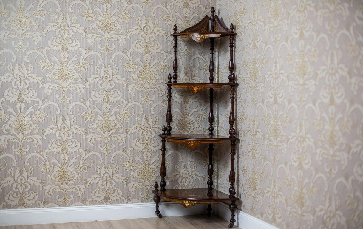 We present you a skeletal piece of furniture, circa 1860, composed of four tiers of shelfs, which are supported by turned balusters in the corners.
The étagère is made of walnut wood; with the shelves veneered with burl and ornate with intarsias