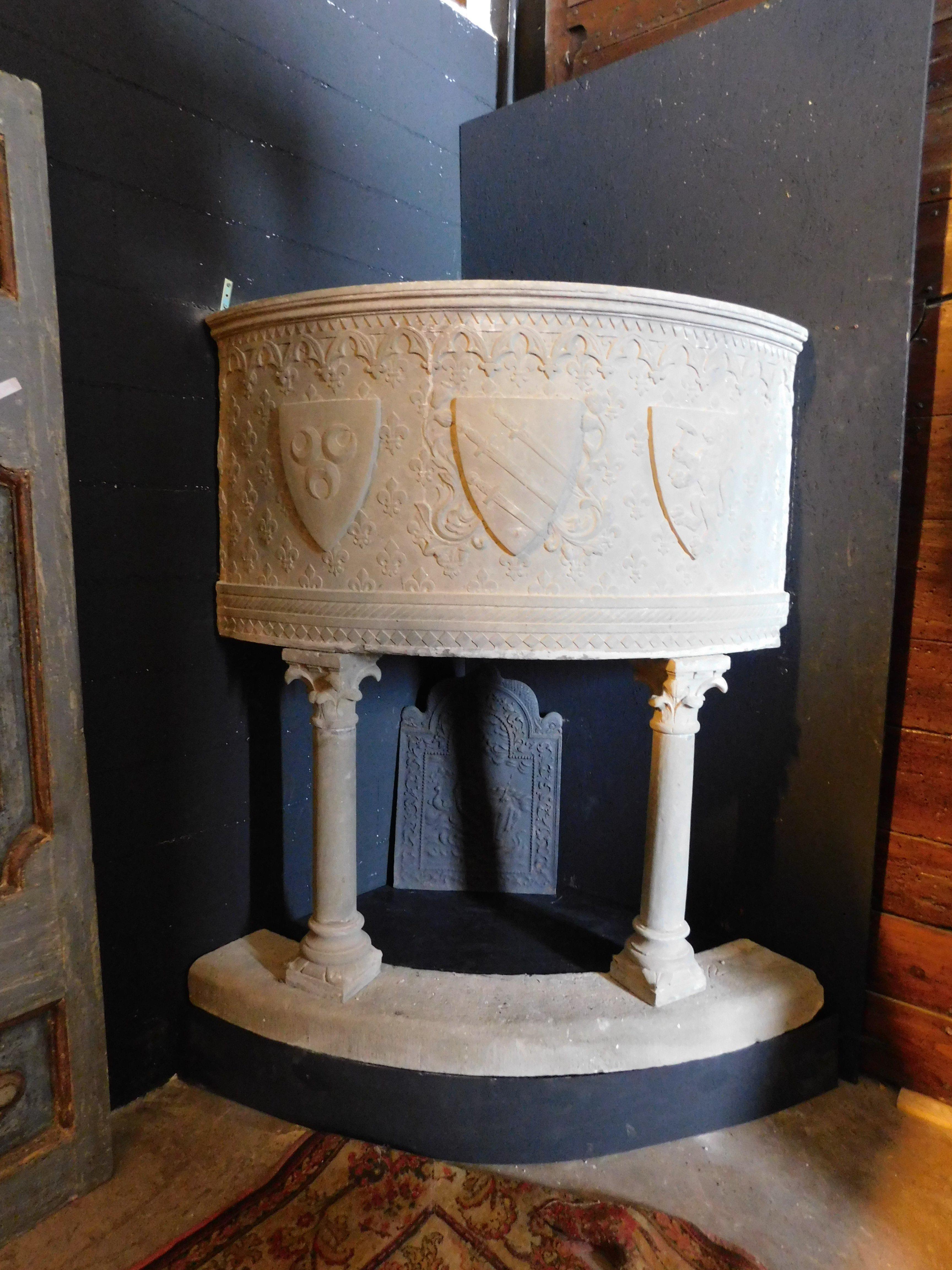 Antique fireplace mantle, built in a corner with original threshold, all in Serena stone, hand-sculpted with noble coats of arms and Gothic columns, coming from an illustrious family in Tuscany from the period between the 1500s and 1600s, maximum