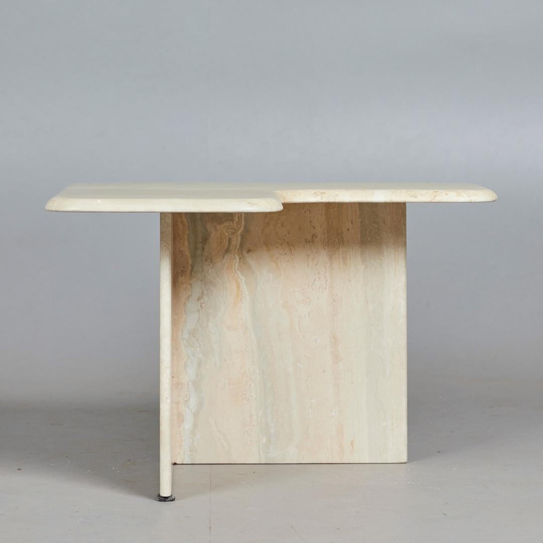Coffee table / side table, travertine, 1970s. Travertine coffee table with an equilateral, trigonal construction, labeled on the underside with an adhesive label.

H.45 cm, L.35-69 cm, W.35-69 cm.