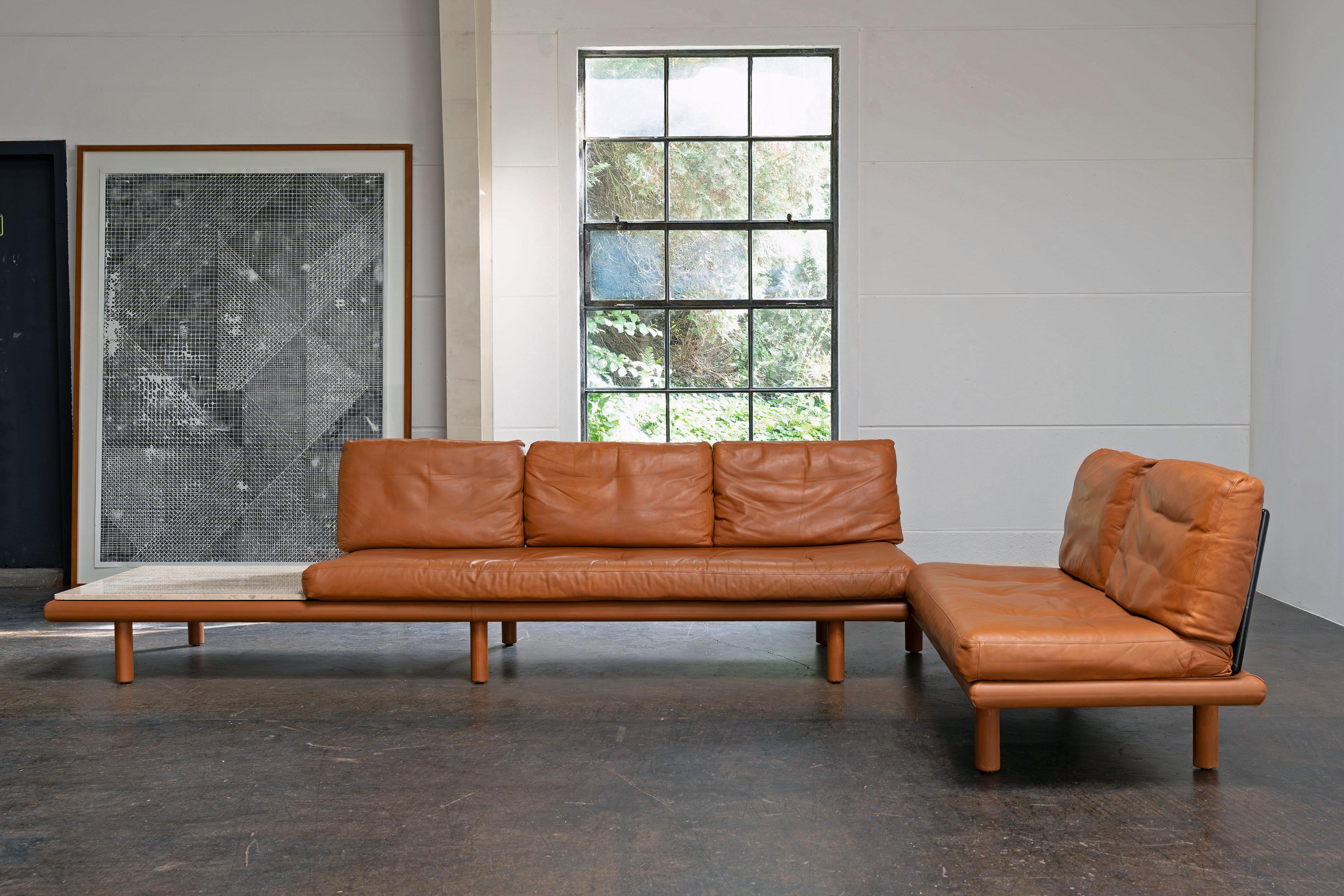 Corner combination consisting of two leather sofas designed by Franz Köttgen and produced by Kill International. The high-quality upholstery is filled with down and covered with glove-soft leather. The sofas each have a travertine table