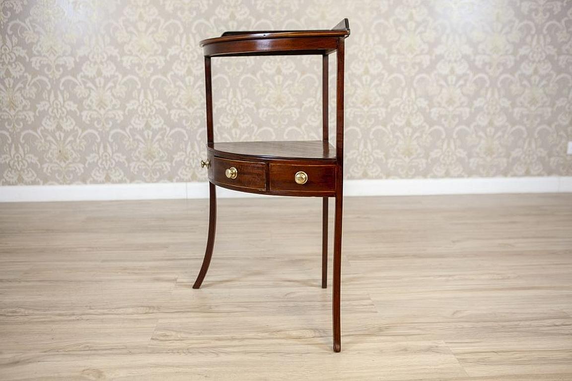 Walnut corner table from the early 20th century in dark brown.

We present you this walnut piece of furniture supported on bent legs, which are connected in the middle section with a desktop.
There are a drawer and two blank drawers with original