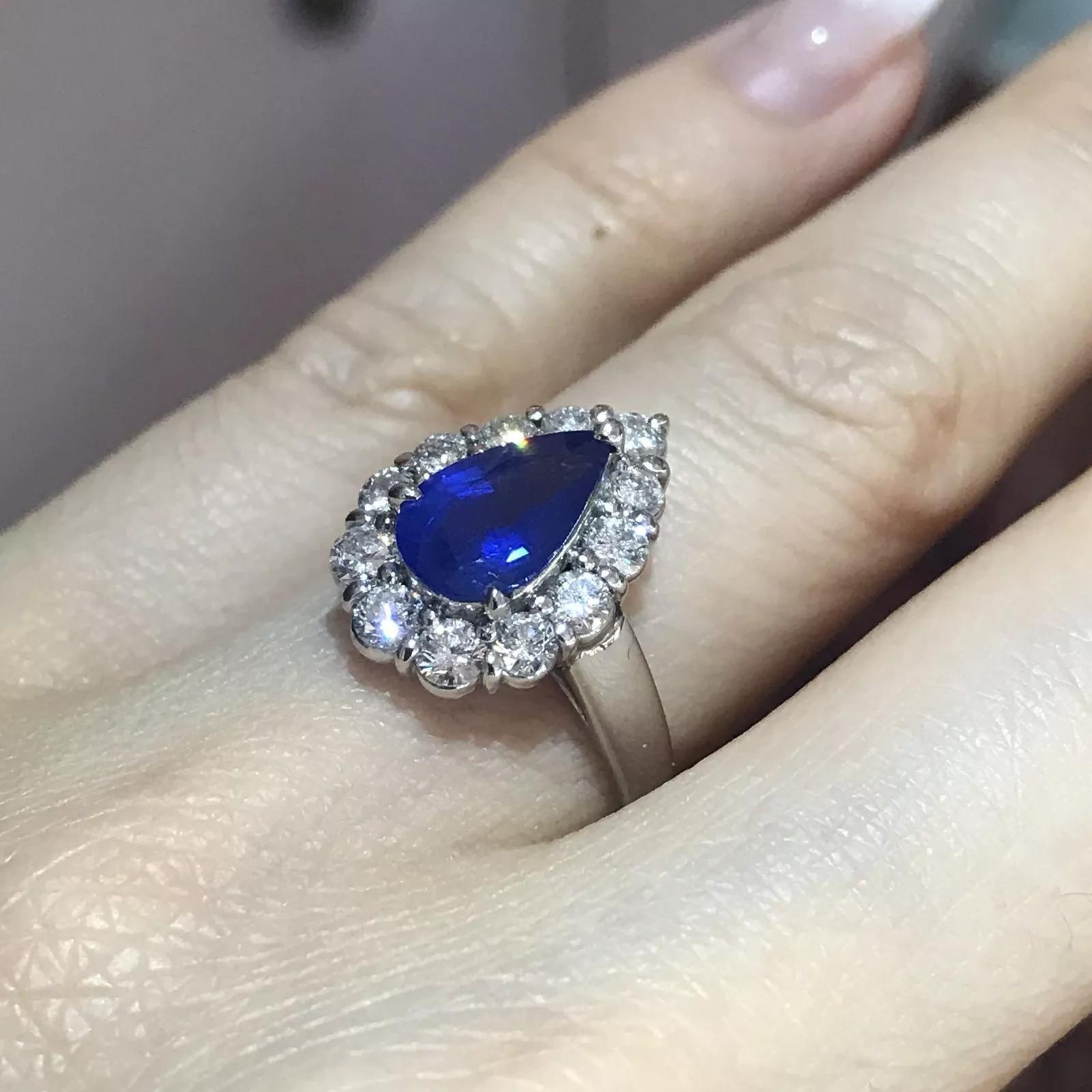 Bague en platine avec saphirs en forme de poire et diamants de couleur bleu corail

La bague en saphir et diamant présente un saphir bleu fleur de poire de 1,83 carat entouré d'un halo de diamants, le tout serti dans du platine.

Le poids total des