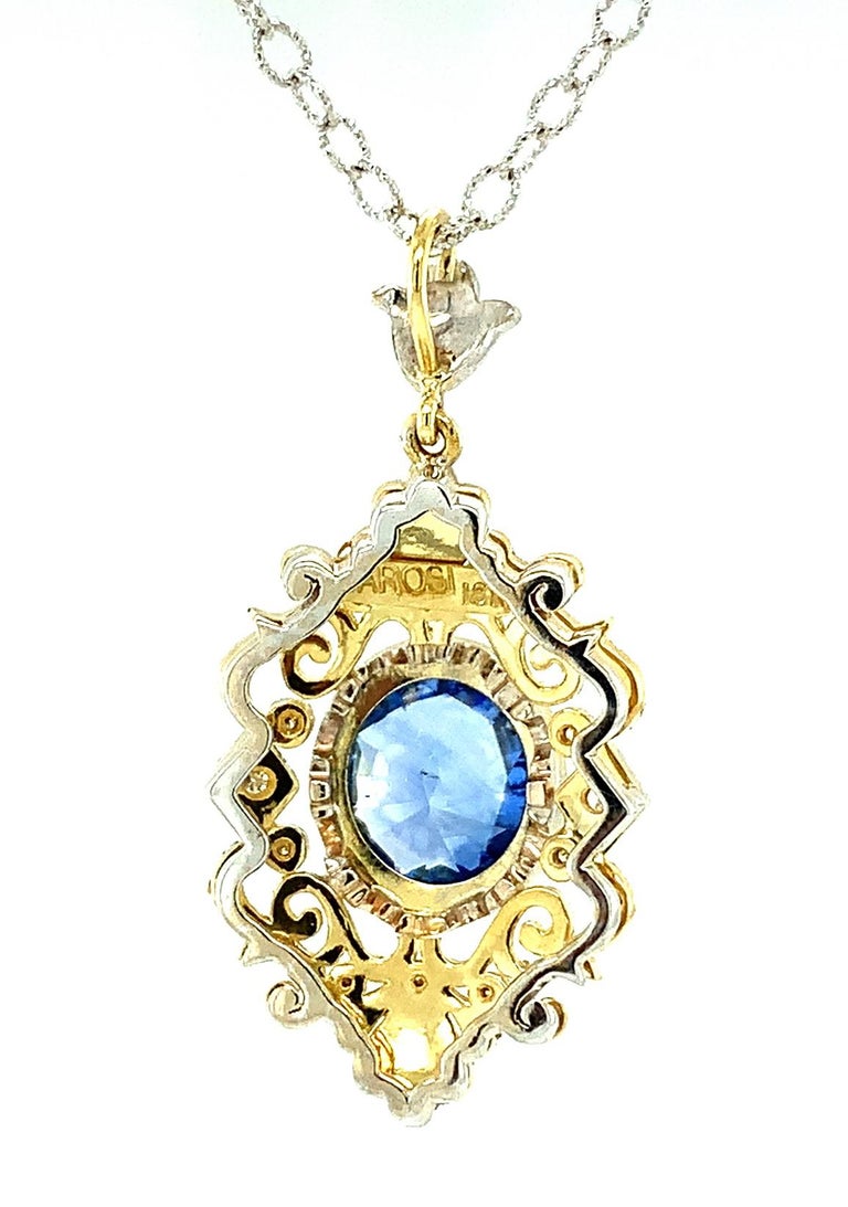 Feel like a royal in this beautifully handmade and intricately designed 18k yellow and white gold sapphire pendant! This gorgeous necklace features a beautiful 2.29 carat Ceylon blue sapphire oval of highly-prized 