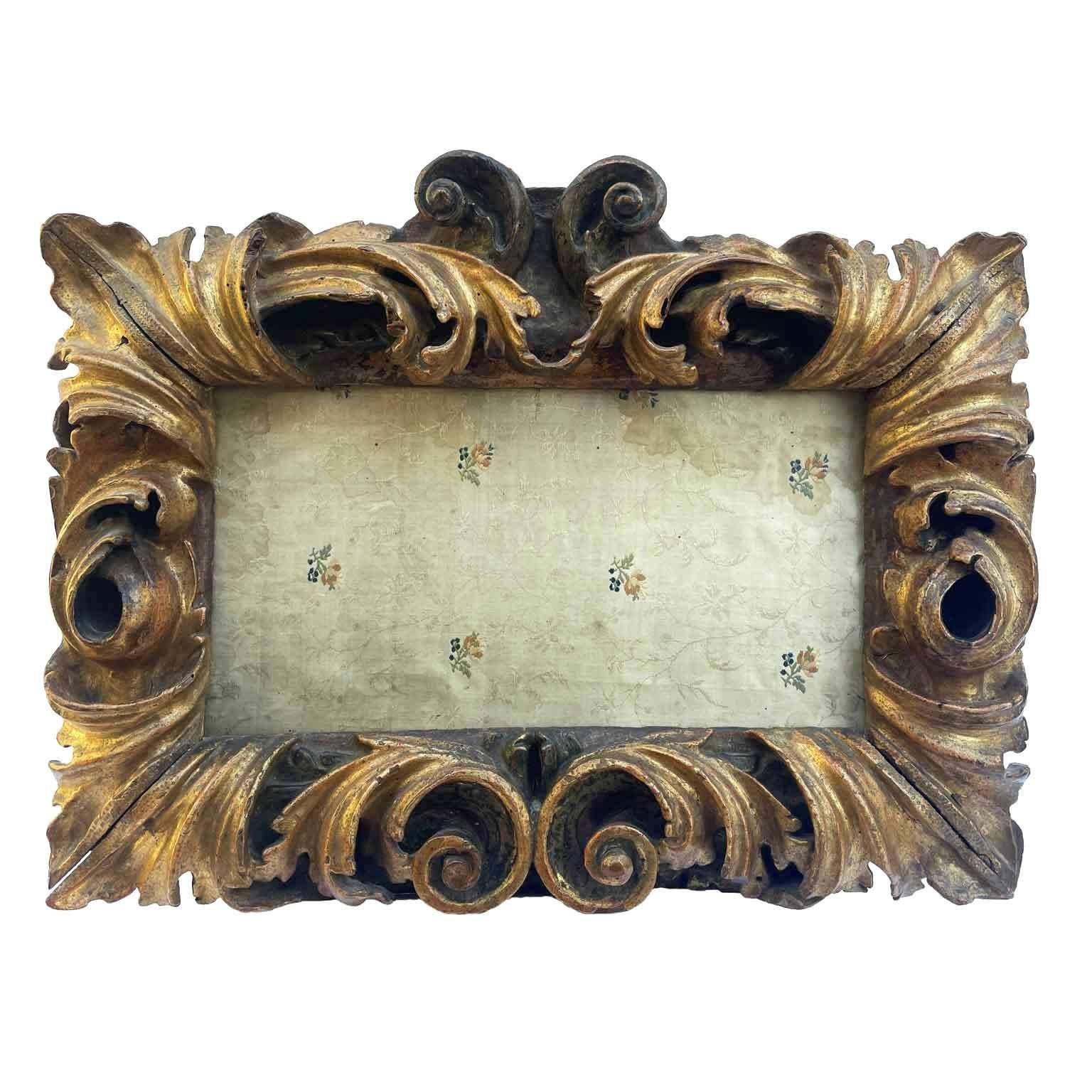 Hand carved Baroque Cartouche frame of rectangular shape formed by deep  volutes that connect with two central keys and foliage with the bulbous ribbing near the corners.  Gilded in fine gold gouache with Armenian red bolus preparation. Inside it is