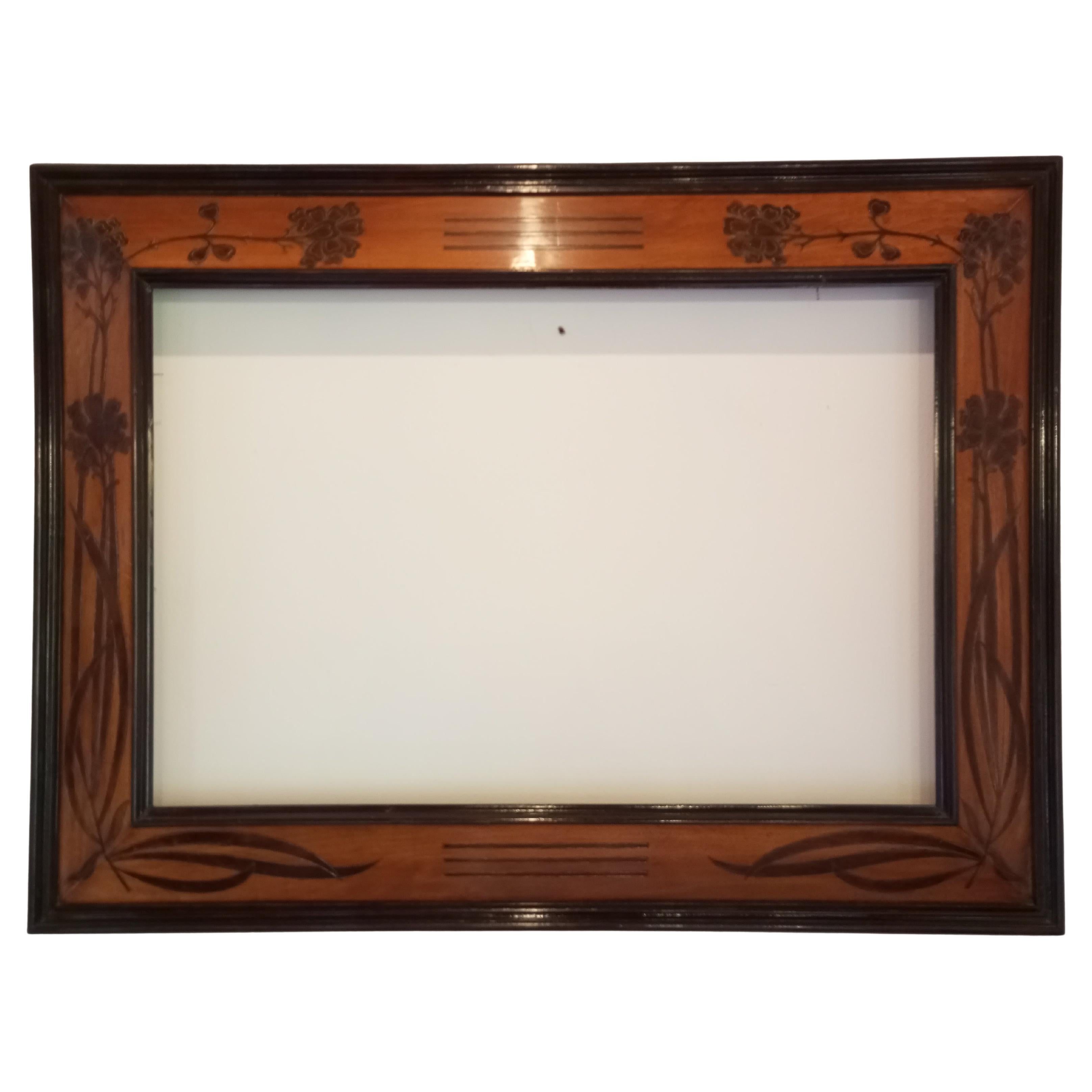 Marco de dimensiones 126 cm. x 95 principios del siglo XX, Austria - Viena. La estructura del marco es de madera de abeto, un material elegido por su ligereza y manejabilidad, mientras que la superficie está finamente chapada con capas de nogal
