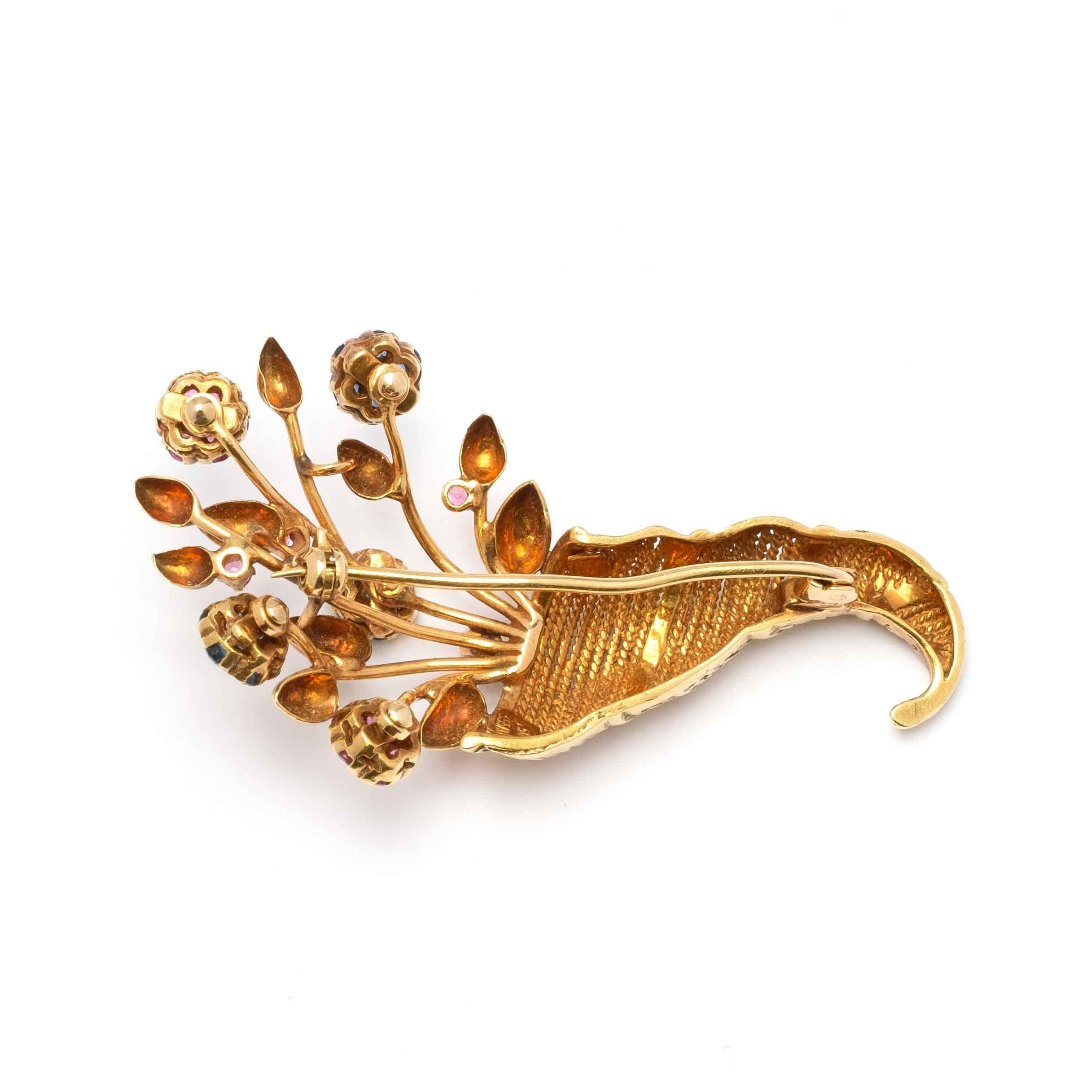 Cornucopia brooch set in 18ct gold, finely decorated with flowers set with rubies, sapphires and emeralds en tremblant. Made in Alessandria, Italy, 1940s period circa.

Highlights:
- 18ct gold
- Natural rubies, sapphires and emeralds en tremblant
-