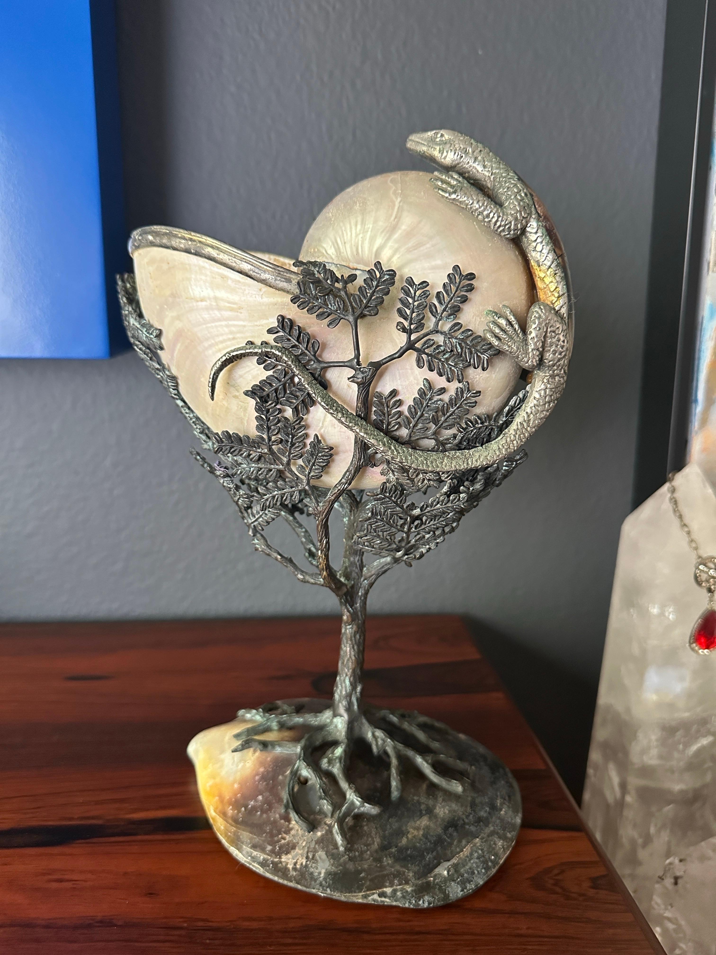 Cornucopia of nautilus shell and lizard mounted on bronze tree in the style of Tony Duqette attributed to Maitland Smith.
Lizard has a beautiful tessellated panshell detail on the back and head.