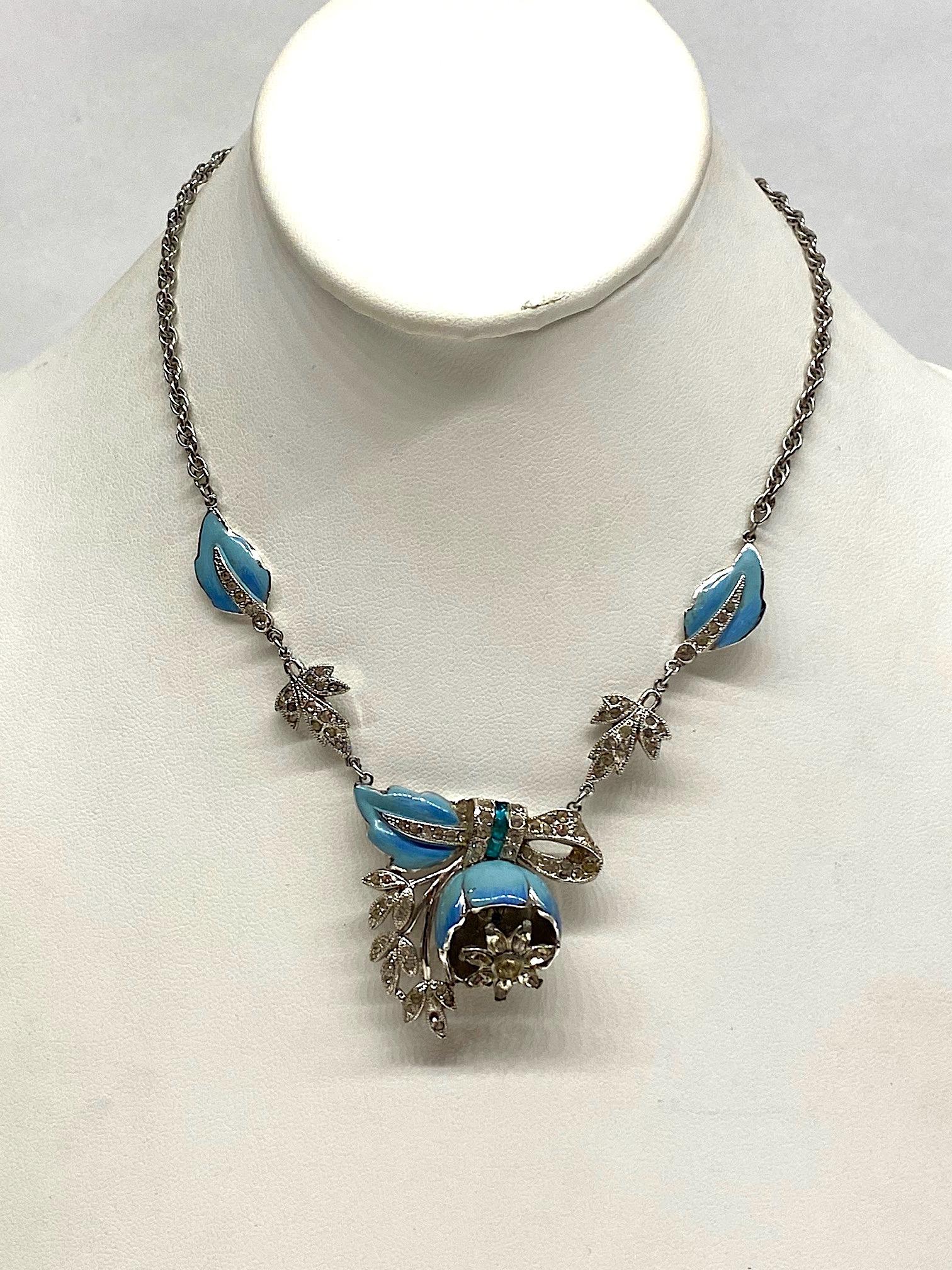 A lovely and rare unsigned Art Deco Coro quivering camellia necklace from 1939 by Adolph Katz. The central part of the necklace features a camellia flower with rhinestone flower on a spring that moves or trembles when worn. The outer part of the