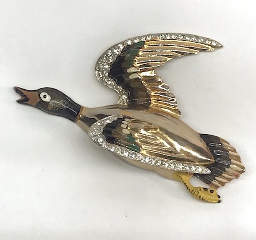 Coro 1940s three dimensional mallard duck in flight brooch. Gold plate with hand painted enamel and rhinestone accents. The brooch is 3.63 inches long, 2.25 inches high and 1 inch deep. It is unsigned but documented in the book 